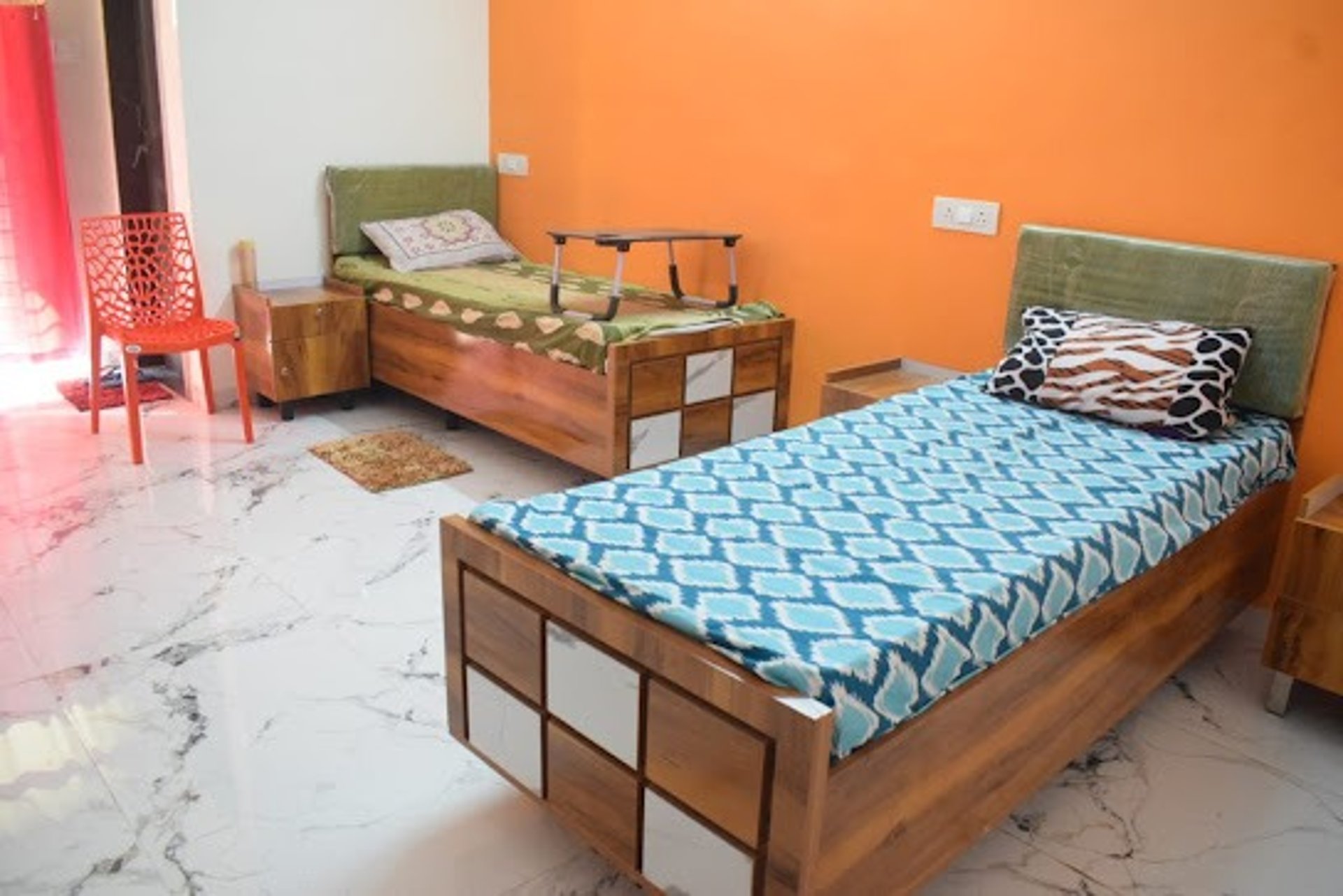 A bed with a red patterned comforter.