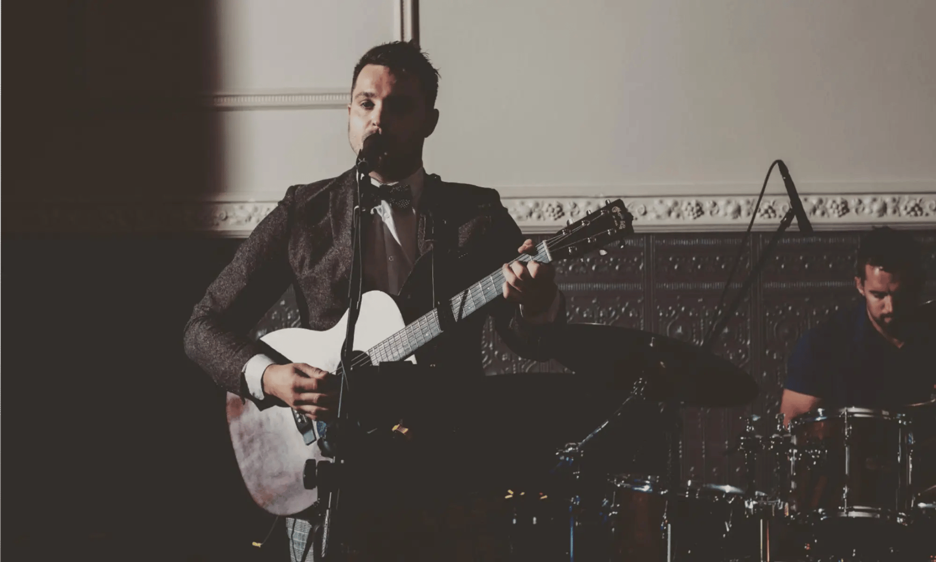 Lead singer of Mosaic performing soulful Americana vocals at a wedding in Devon