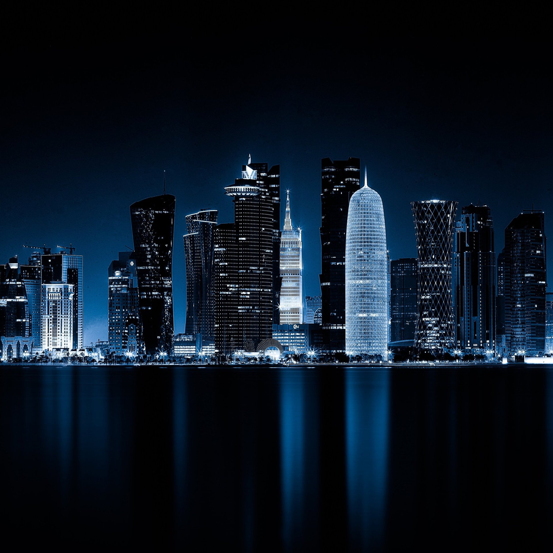 a group of tall buildings sitting next to a body of water