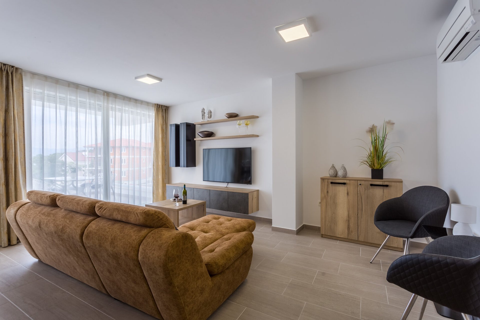 Wohnzimmer mit gemütlichem Sofa und TV im Ferienapartment in Malinska