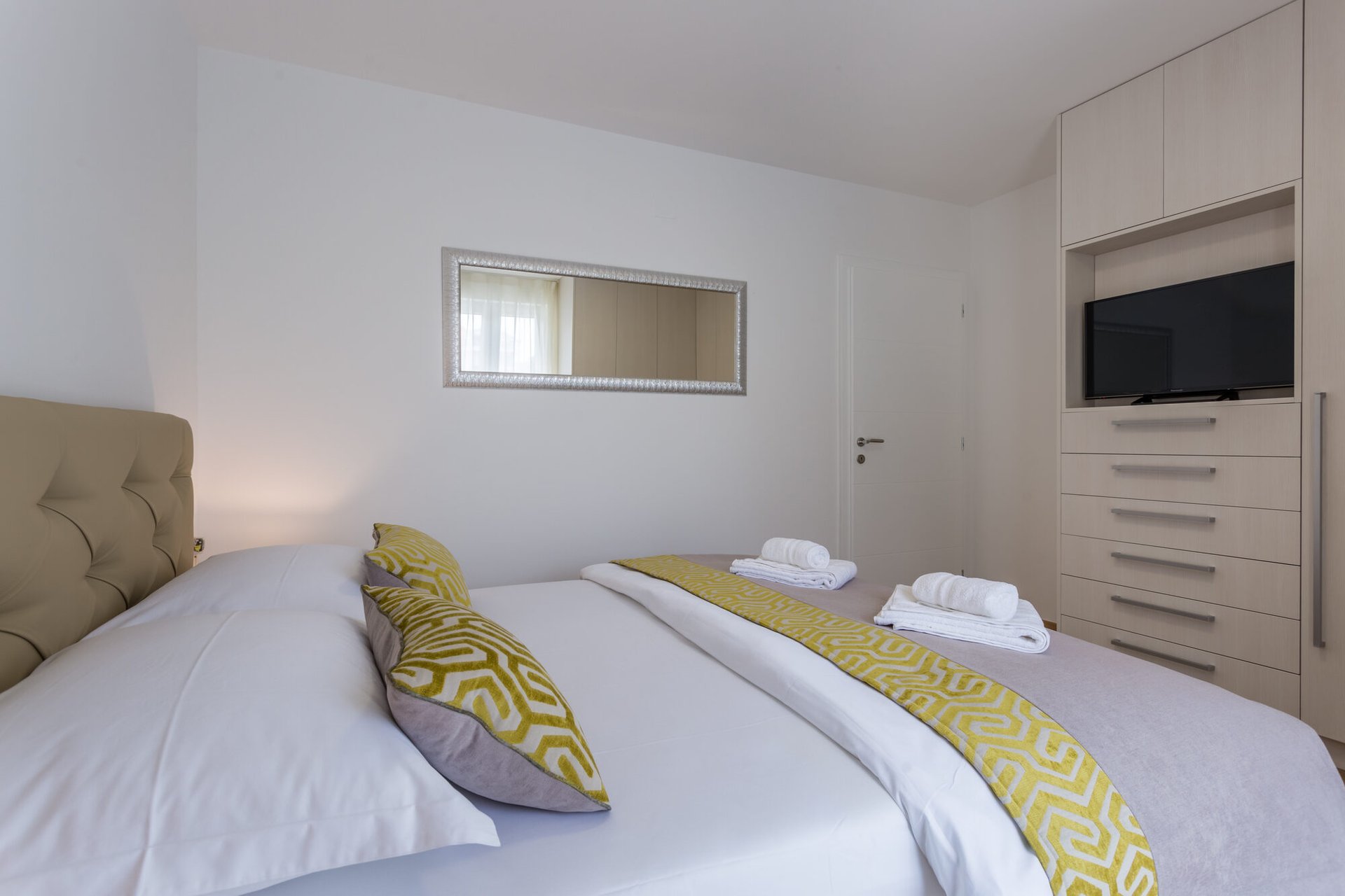Schlafzimmer mit zwei Einzelbetten und TV im Apartment Pure Relax