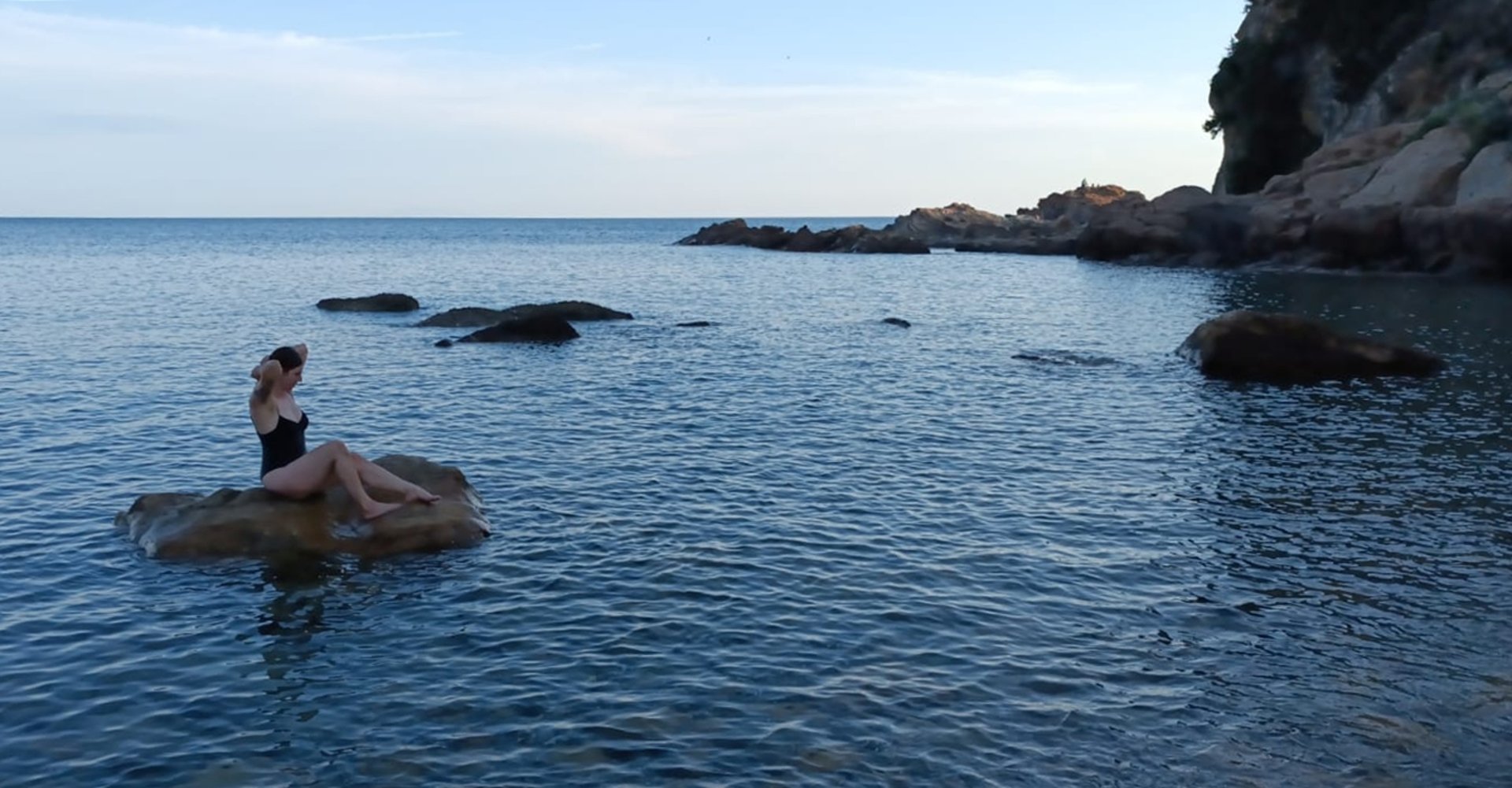 woman in white tank top raising her hands