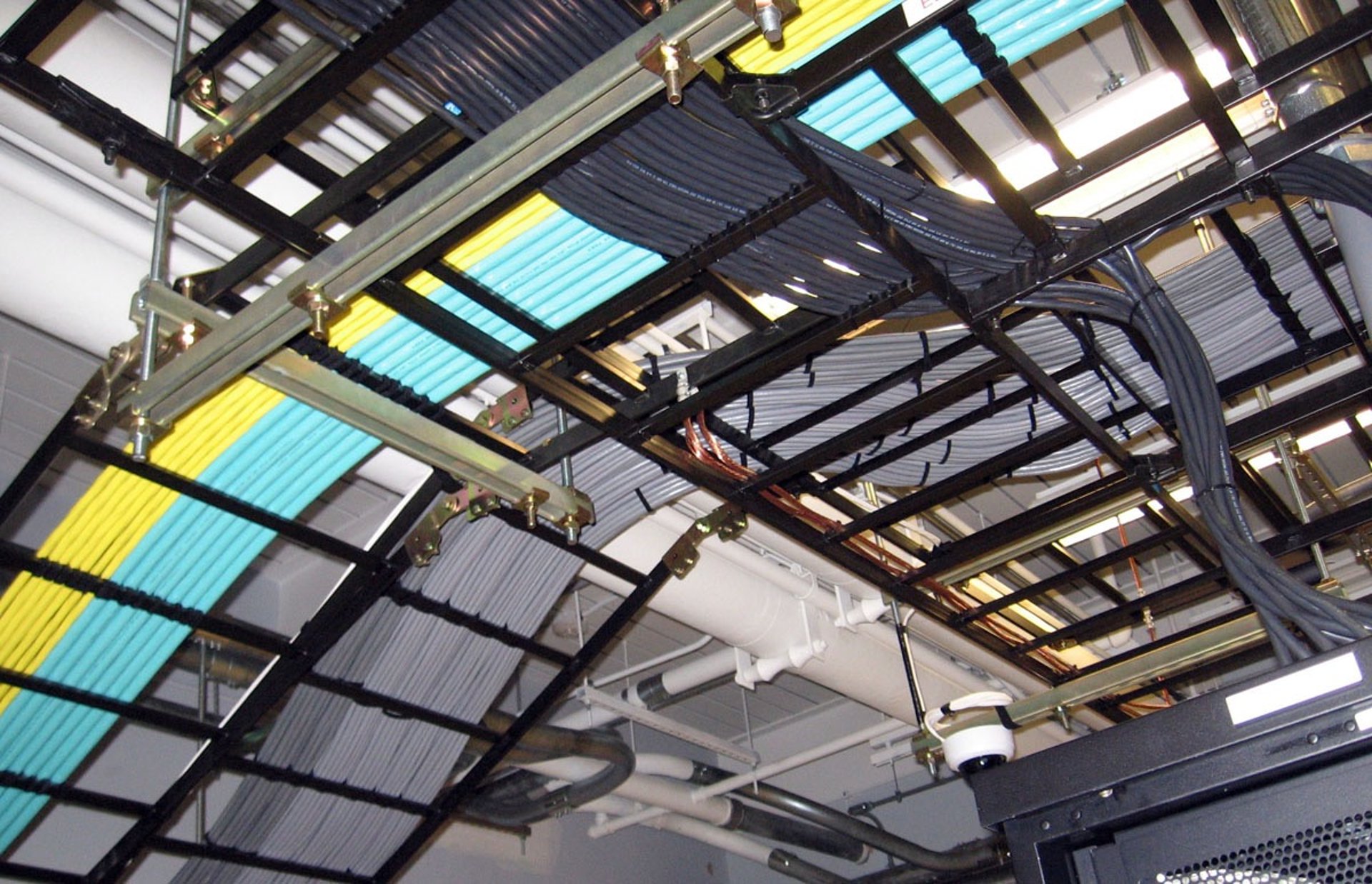 Detailed view of an overhead cable tray system filled with colorful wiring.