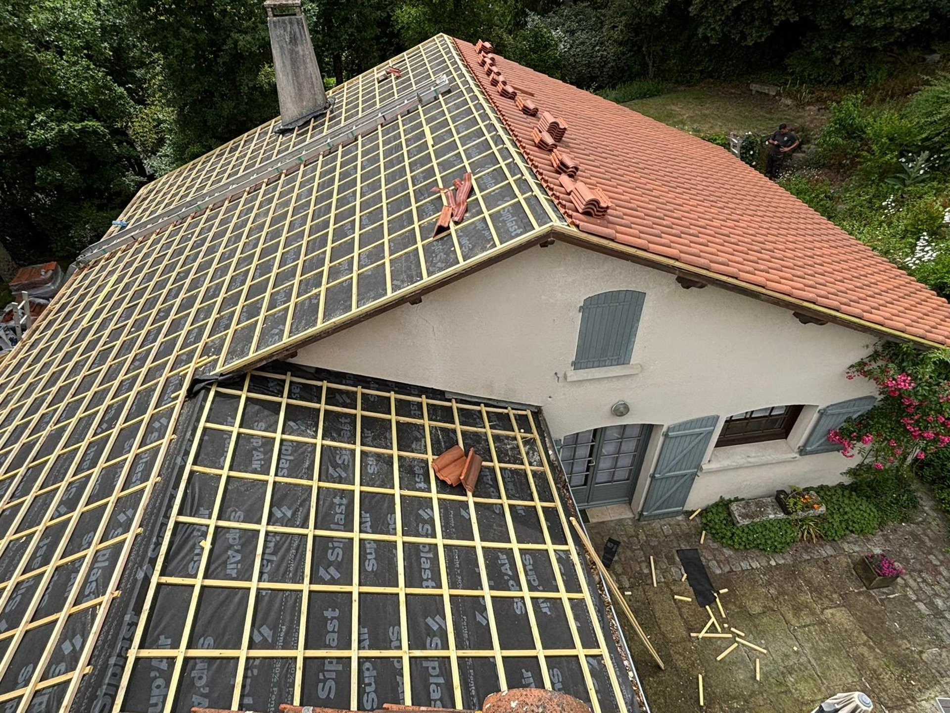 a man in a yellow shirt is working on a roof