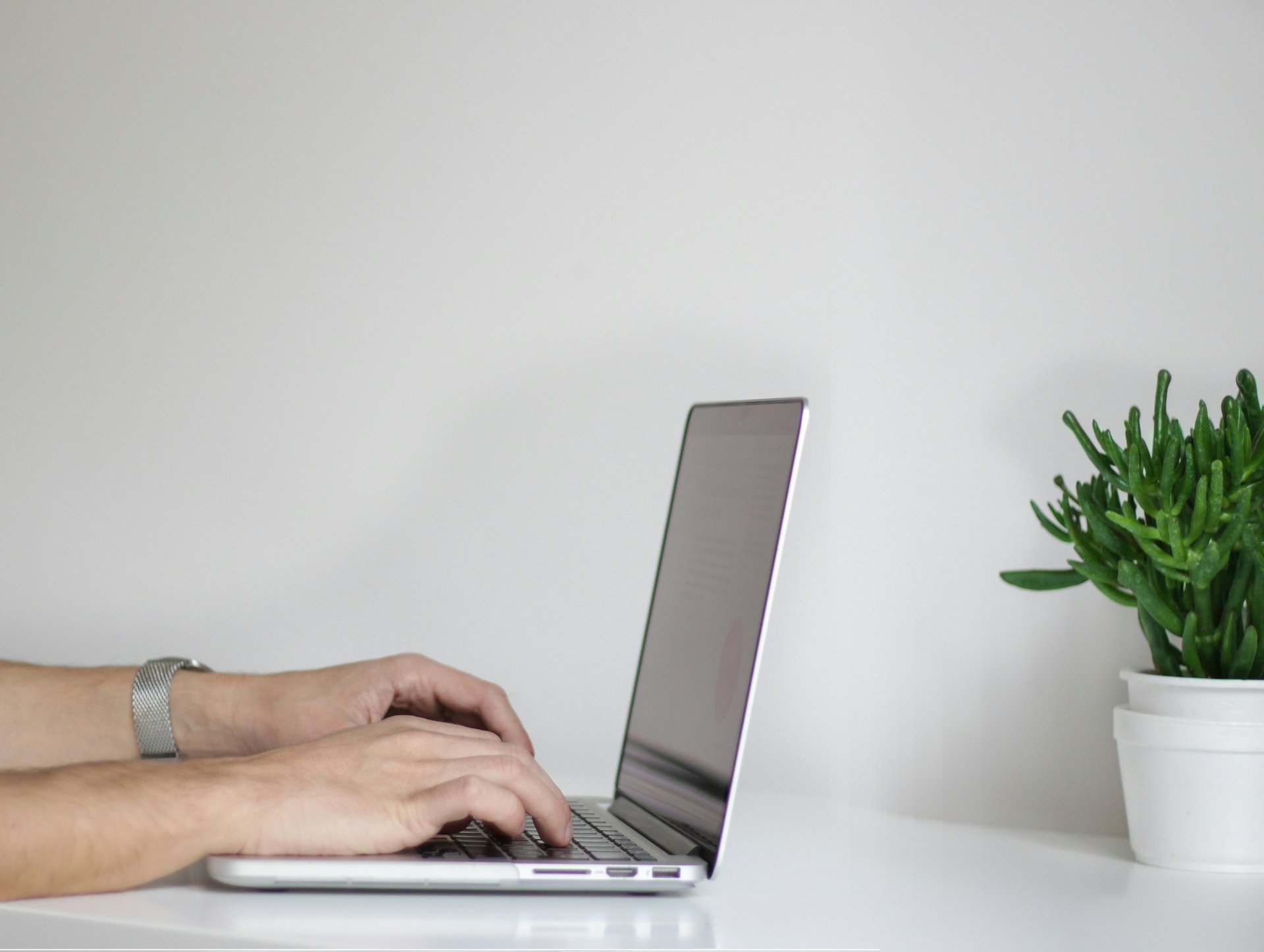 person wearing watch near laptop