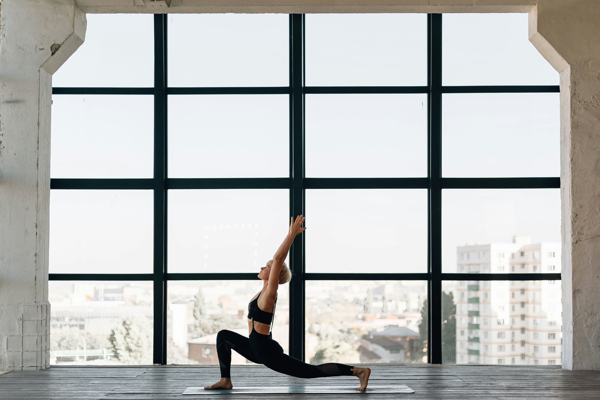woman in black pants standing on window during daytime