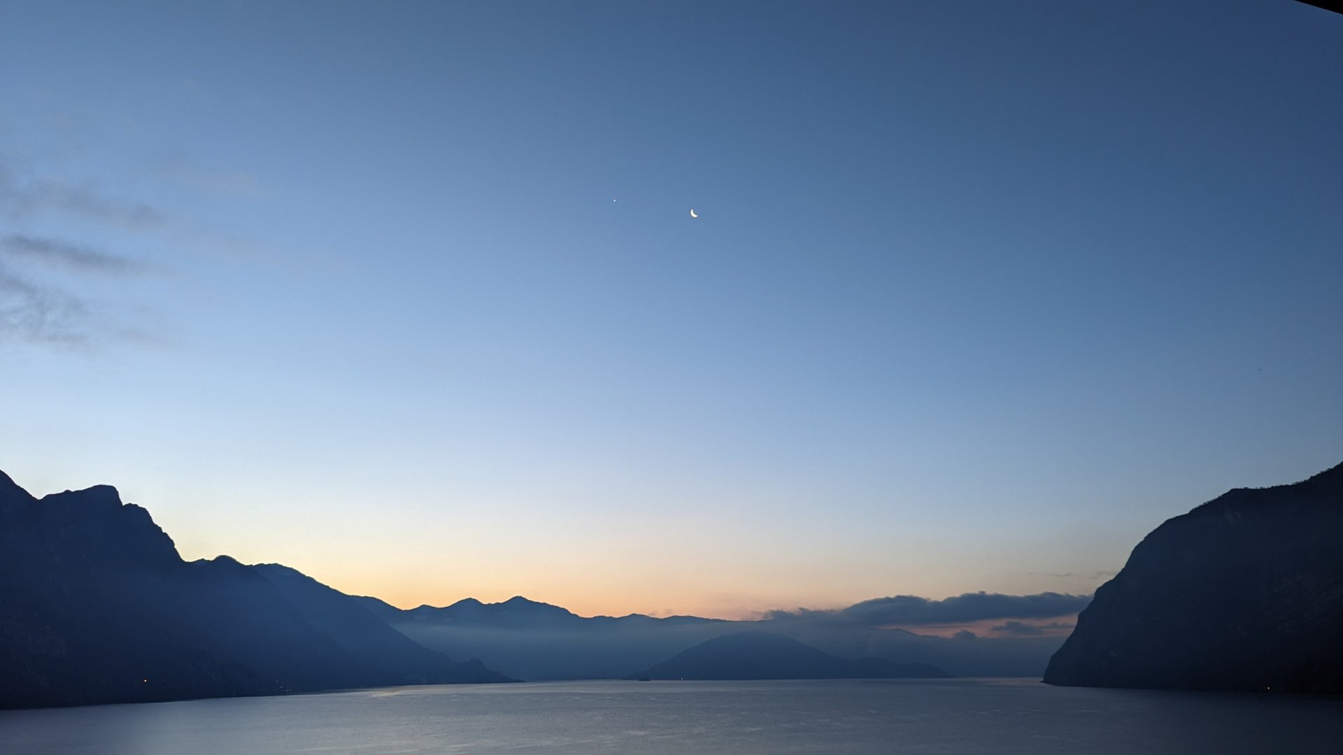 calm body of water near alp mountains during nighttime
