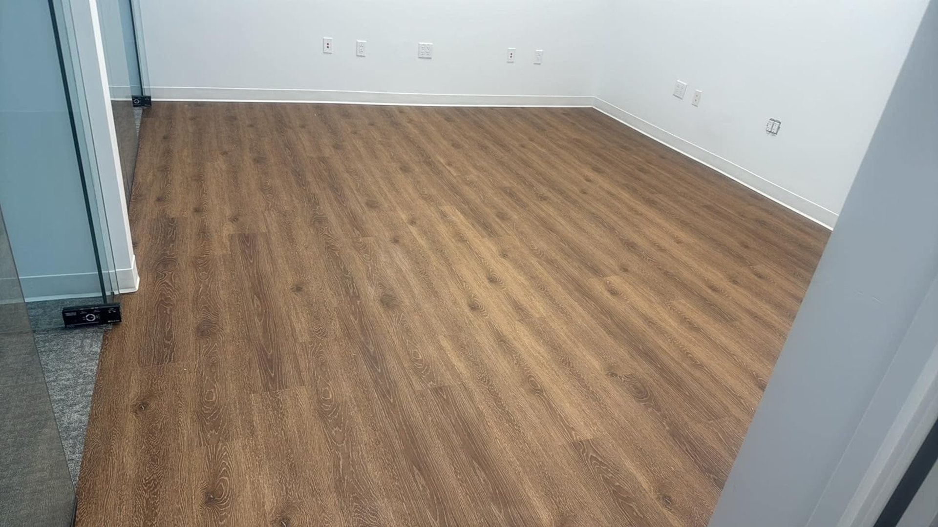 An empty room with a wood floor and white walls