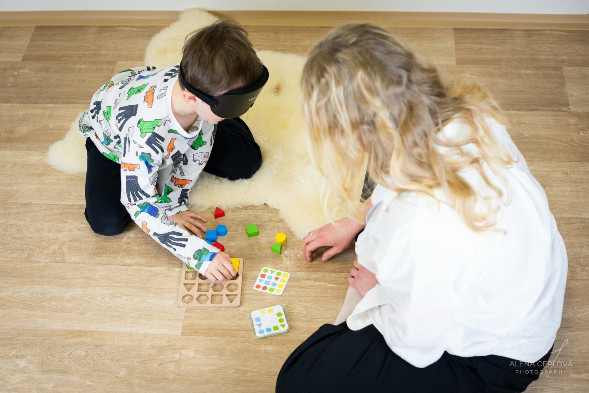 boy in orange crew neck t-shirt standing in front of white wooden table with cupcakes