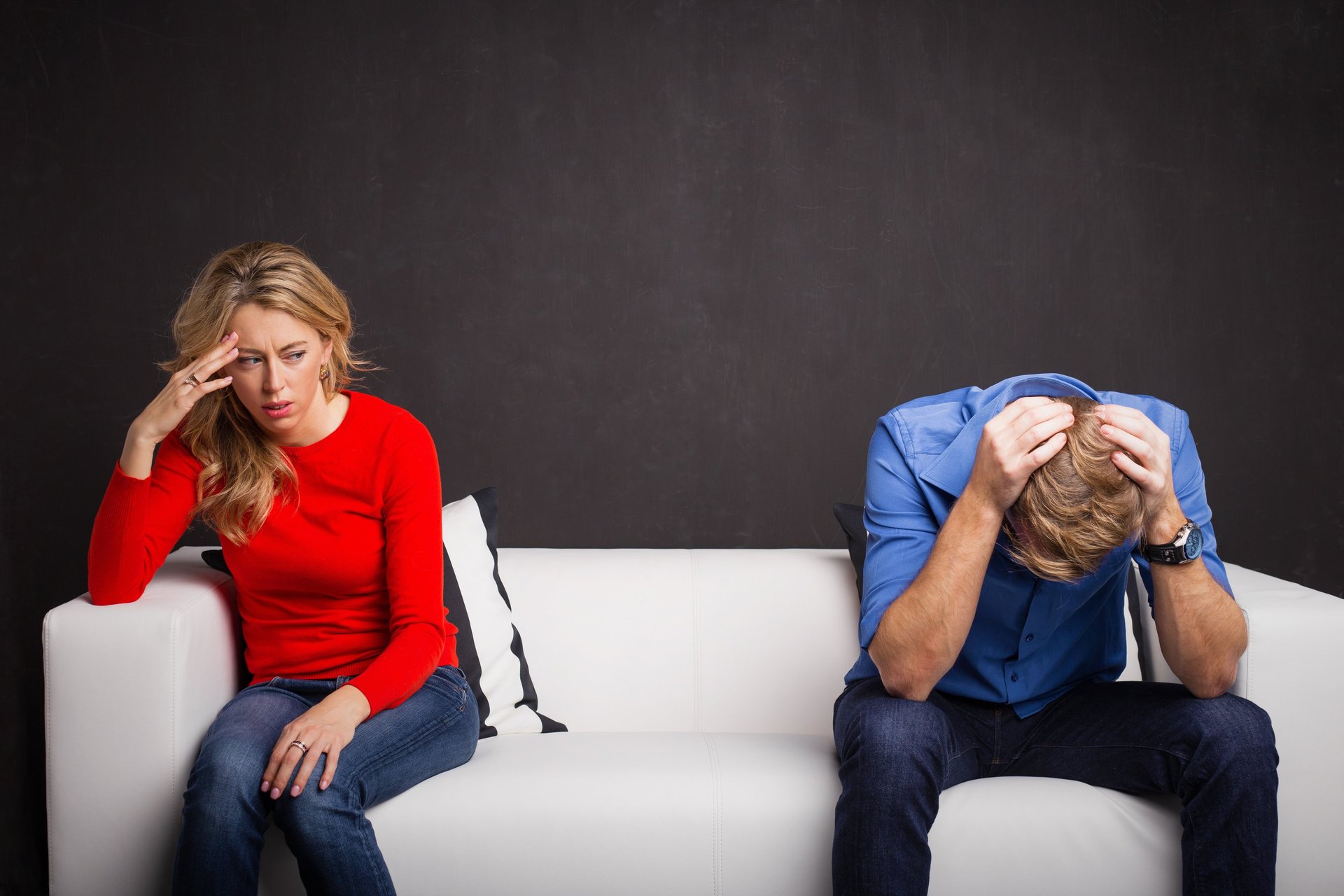 A couple sitting on the couch is upset, and having a communication brakedown