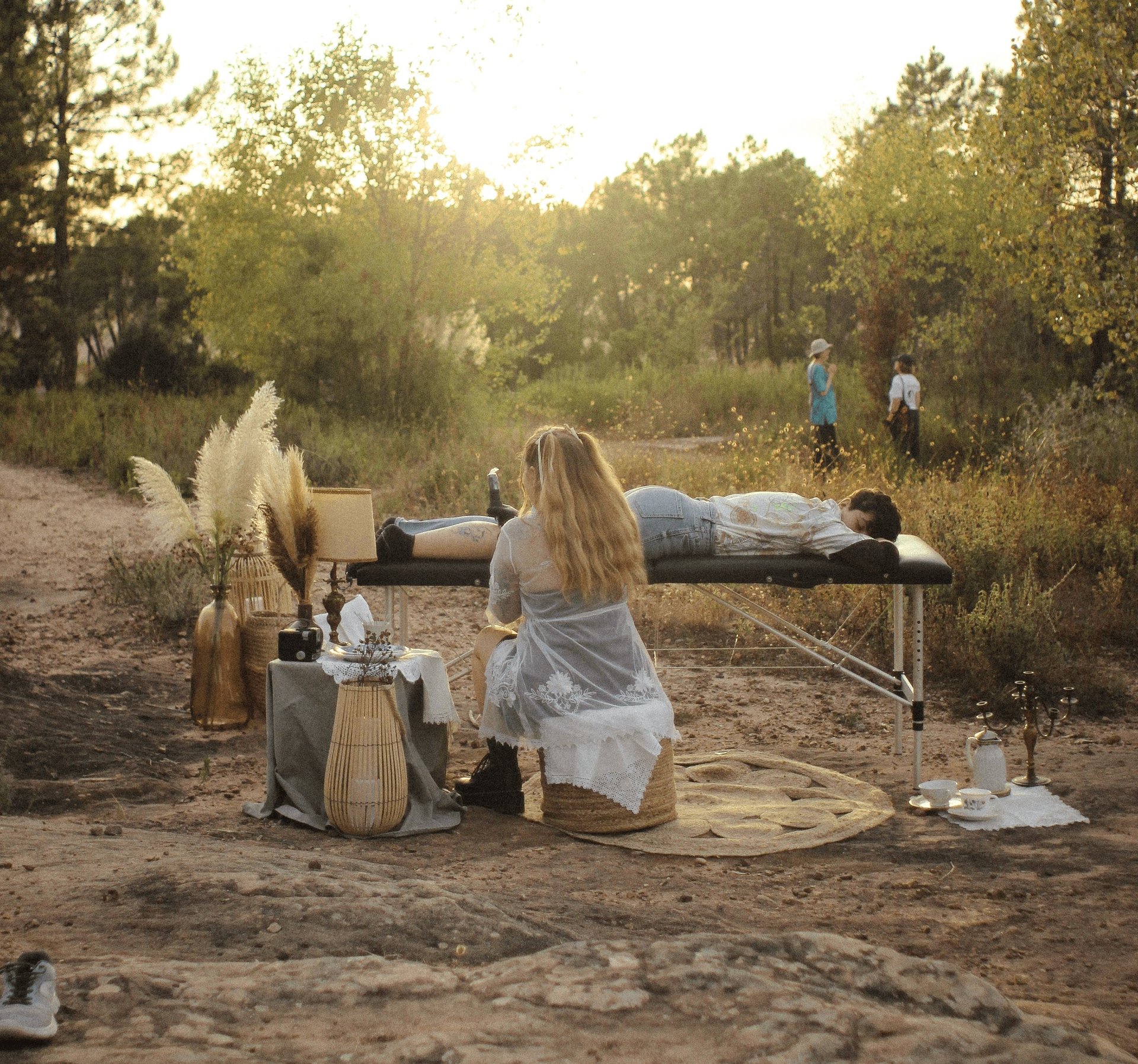 photo lointaine d'Eva Ink vlr qui tatoue Minuit Tattoo en extérieur, dans une ambiance aux couleurs chaudes