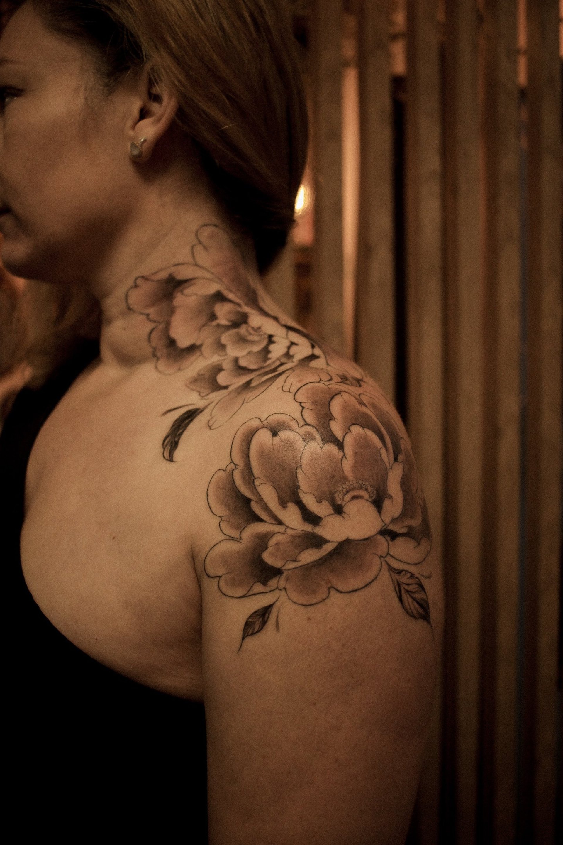 pivoines japonaises tatouées sur l'épaule d'une cliente de Minuit Tattoo