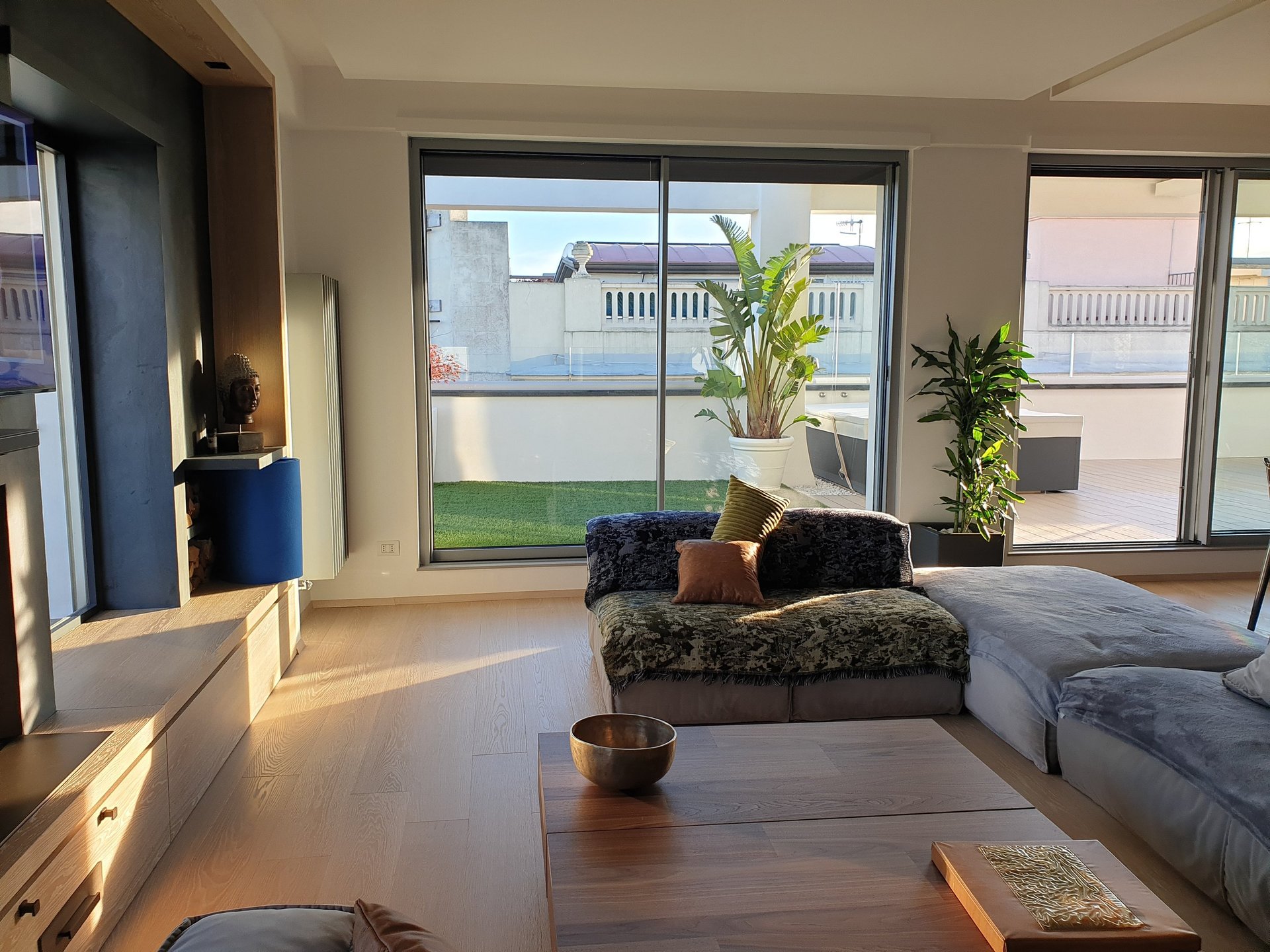 an unmade bed with a view of a forest