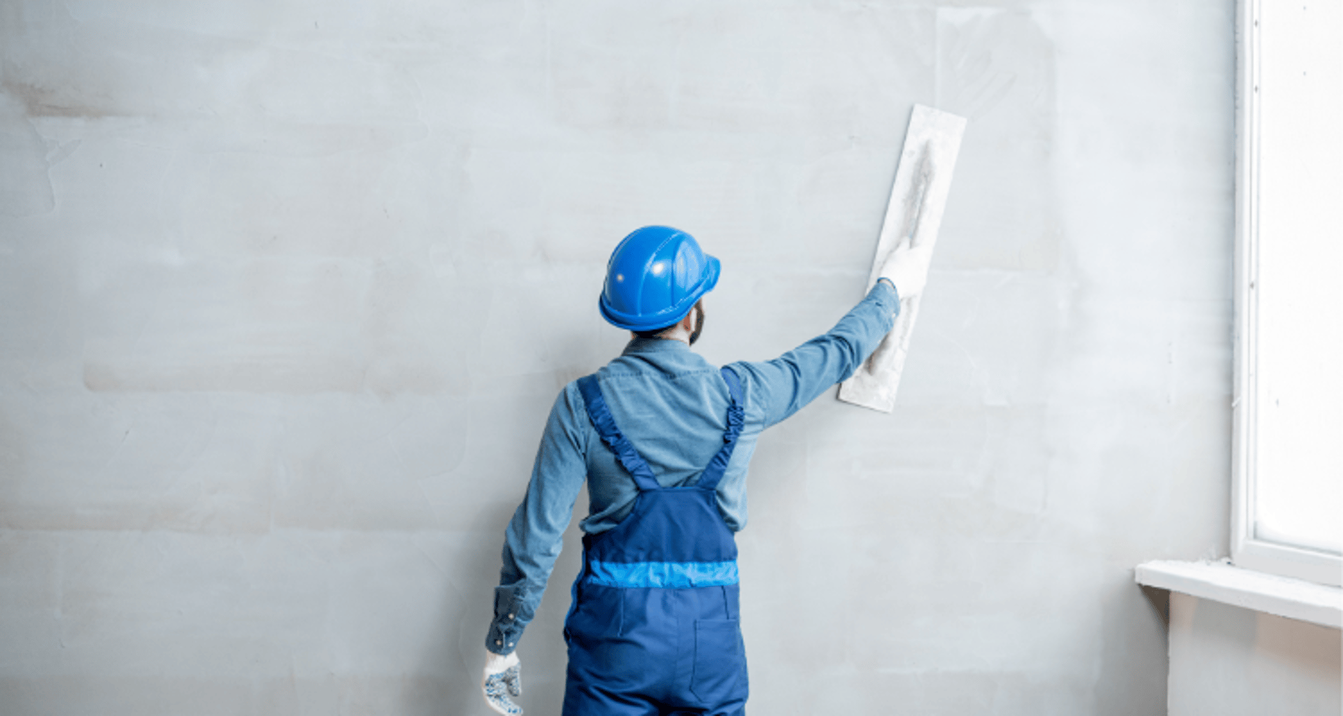 a man painting a wall with yellow paint