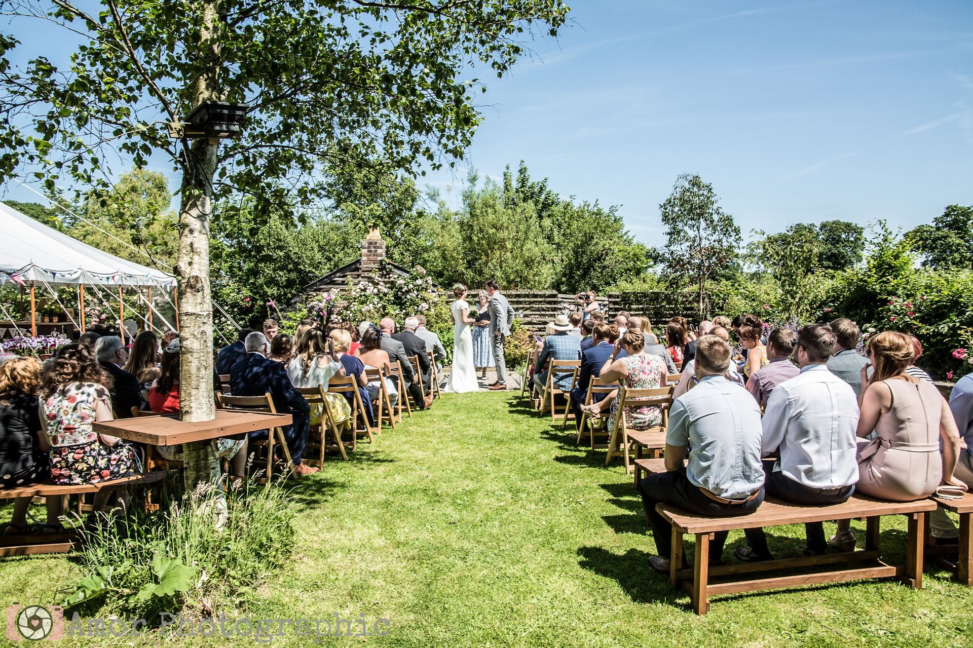 Outdoor wedding ceremony on the lawn with guests in rows at The Secret Garden Wedding venue