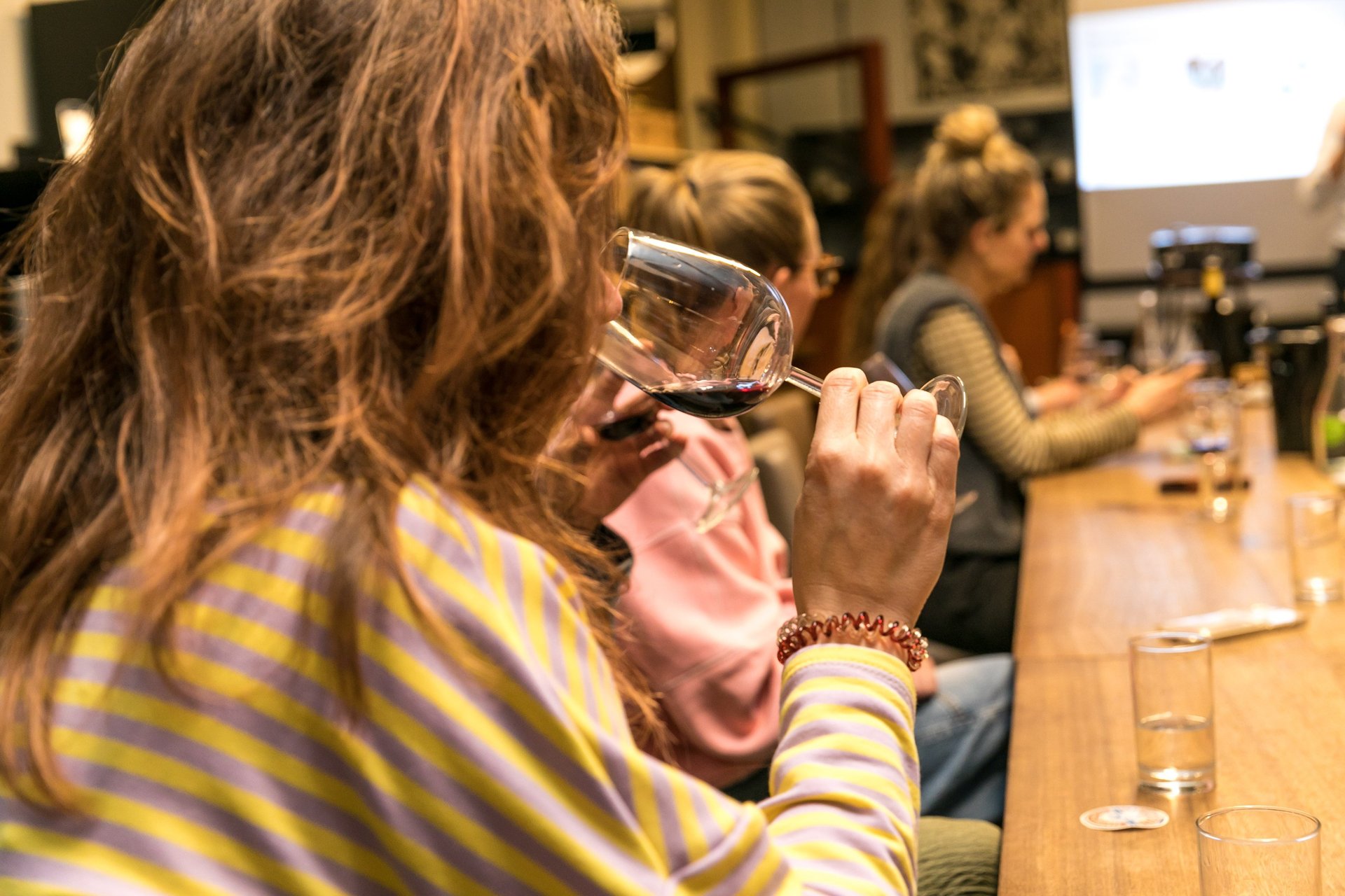 a group of people sitting around a table with wine glasses