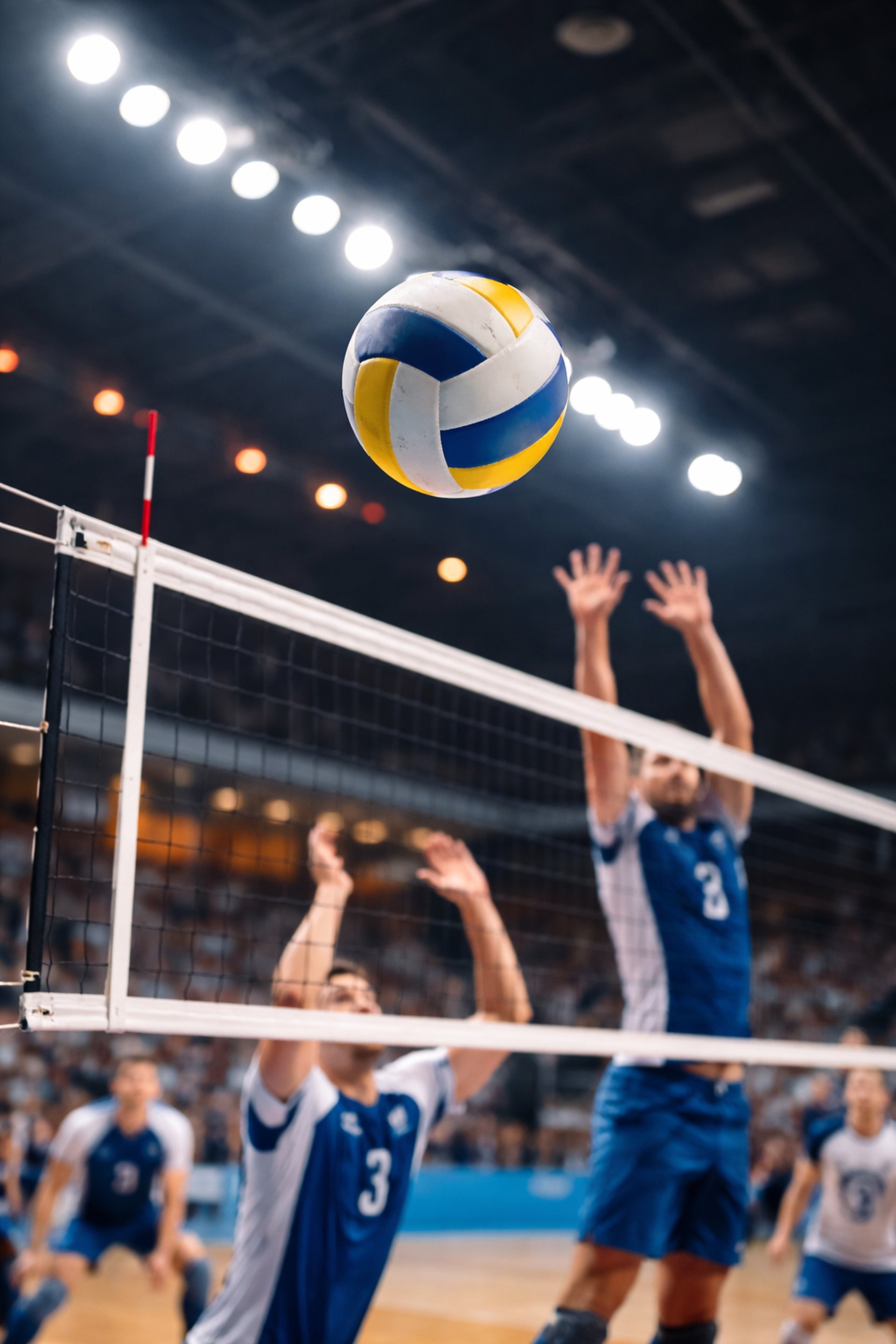 Volleyball am Netz mit Blockszene und Ball im Flug in einer Indoor Halle