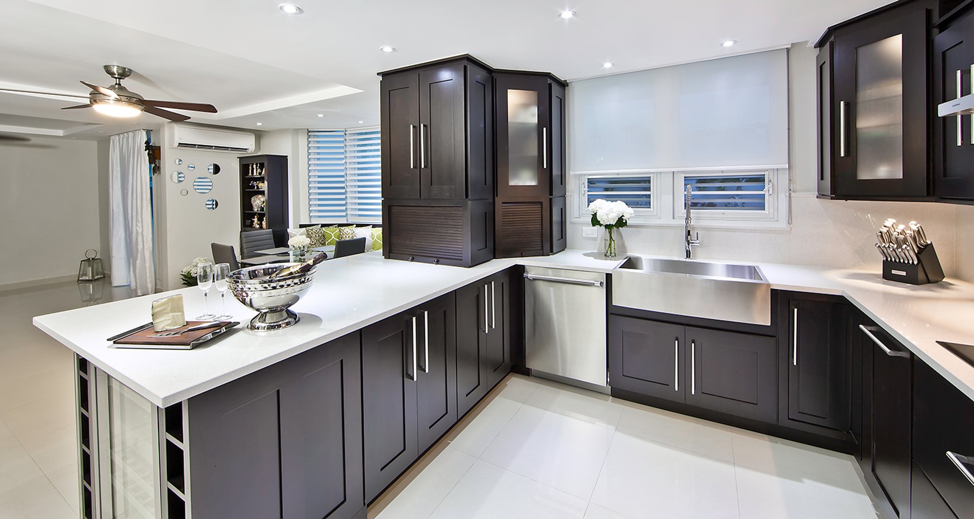 a kitchen with white cabinets and a large window