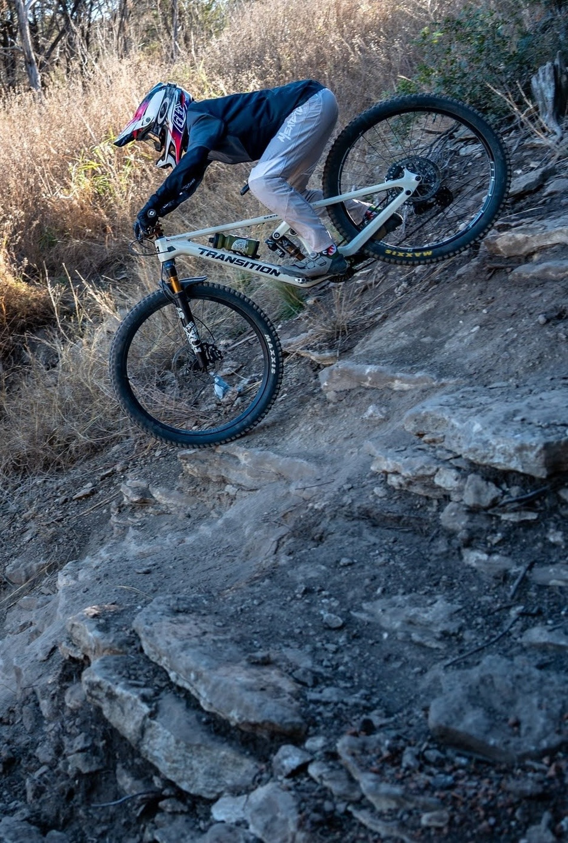 person mountain biking down steep hill