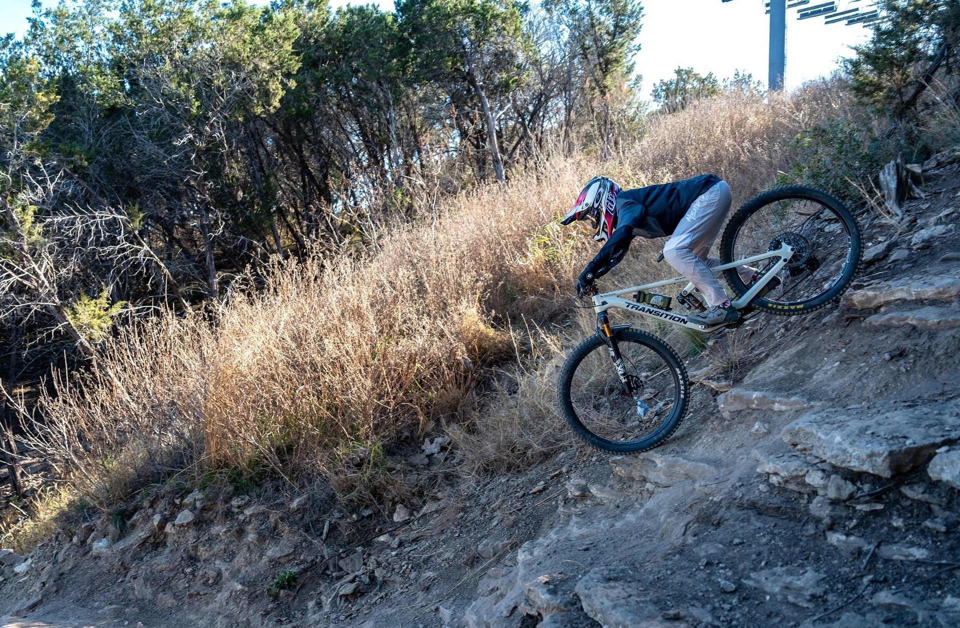 person mountain biking down steep hill