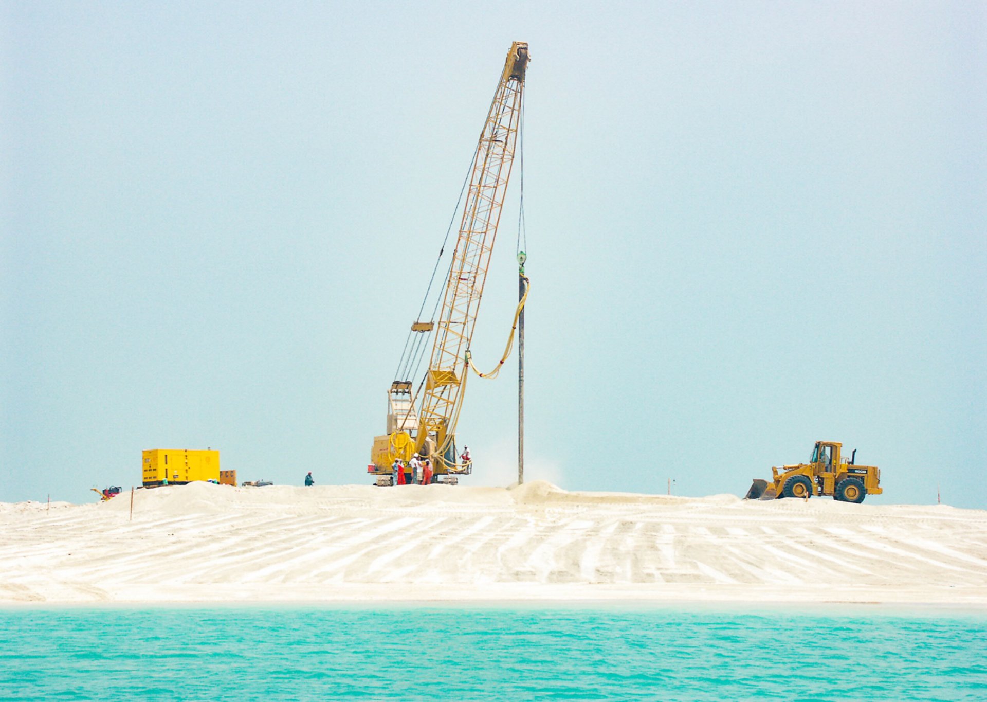 yellow and black excavator on rocky ground