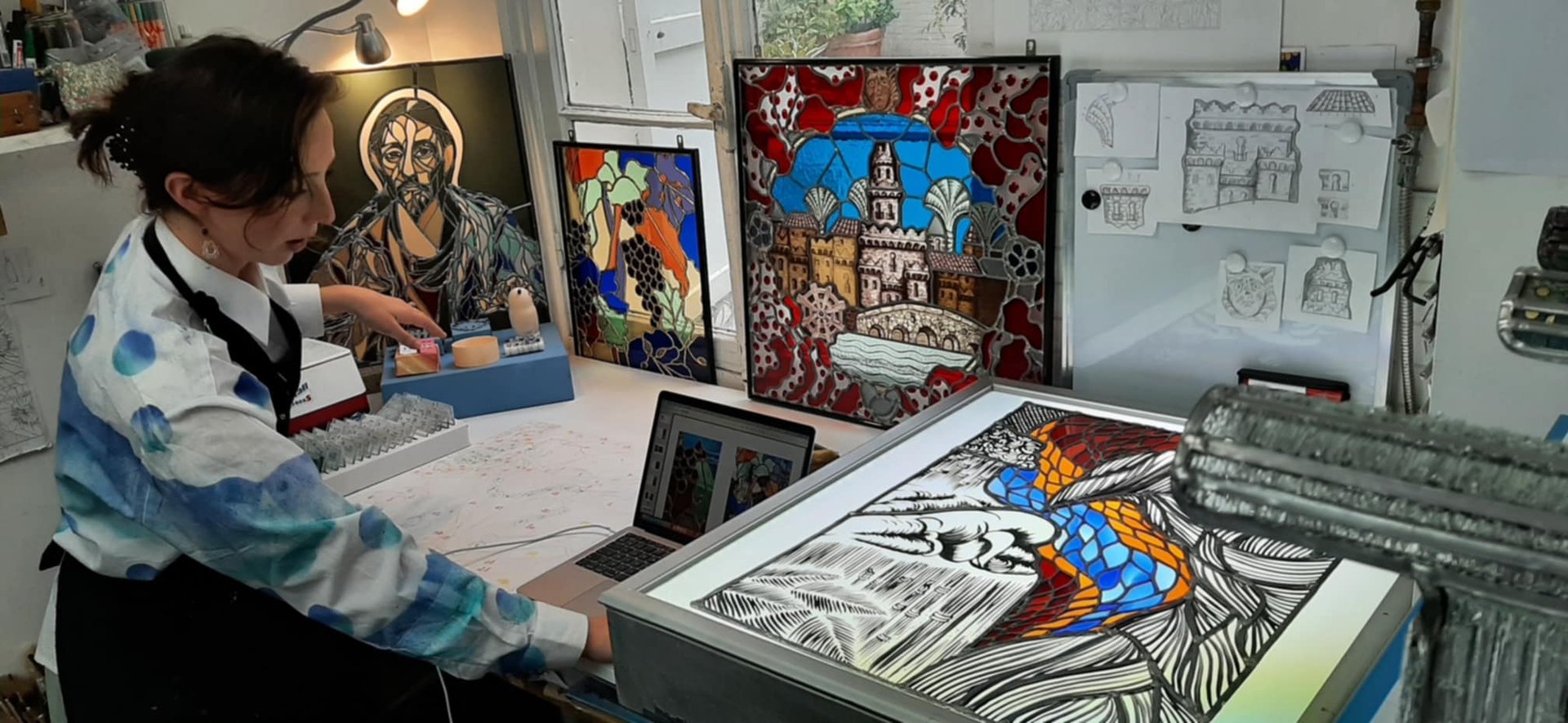 L'artiste Édith Théret au travail dans son atelier parisien, entourée de ses créations en verre.