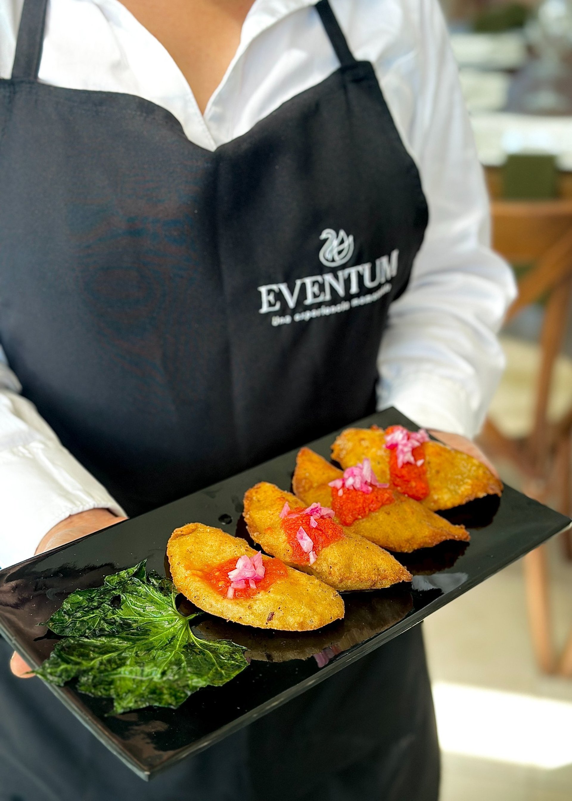 a person in black gloves putting food on a plate