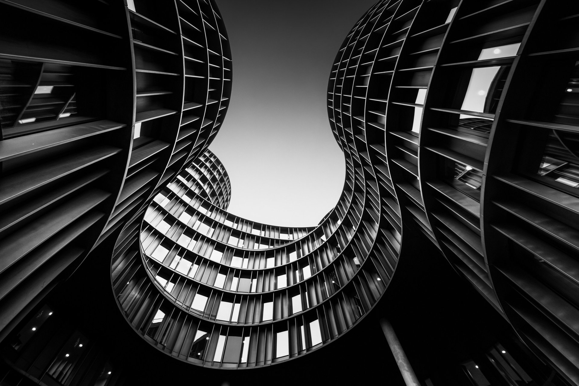Fine art architecture photograph "The Curves" by Anna Wacker — spiralling curved atrium facade looking upward