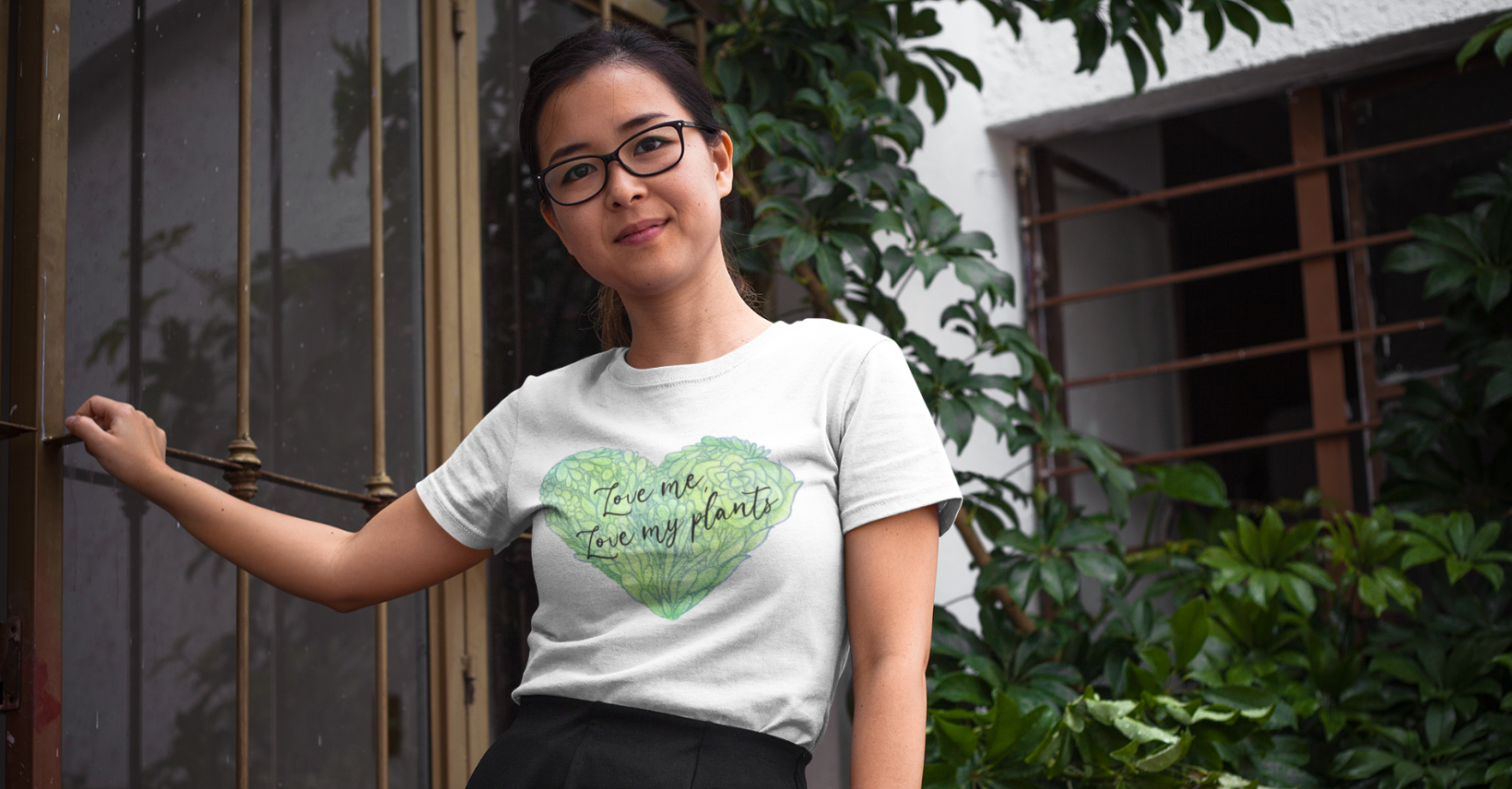 Woman wearing Miss Chatty Plants “Love Me, Love My Plants” white t-shirt with green heart design