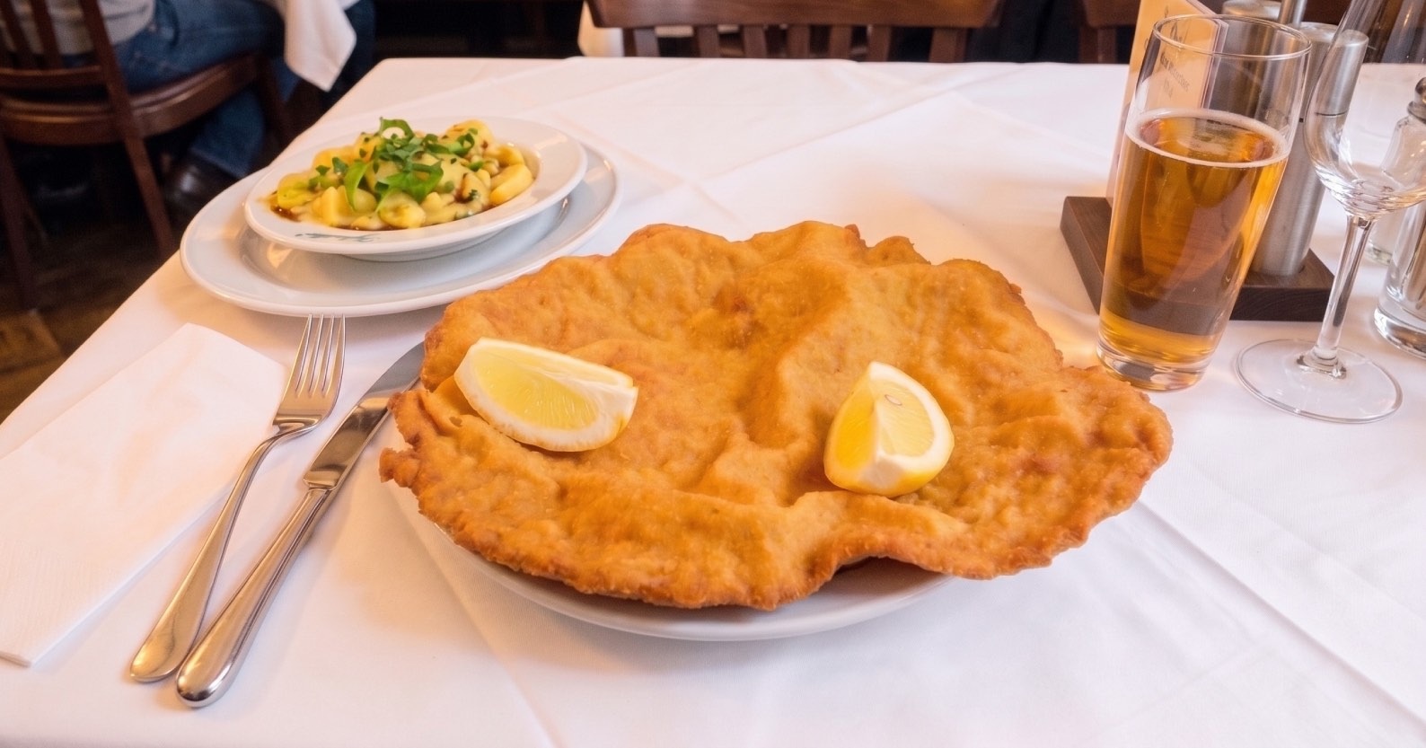 Un auténtico plato de Wiener Schnitzel (escalope vienés) dorado y crujiente, servido con limón