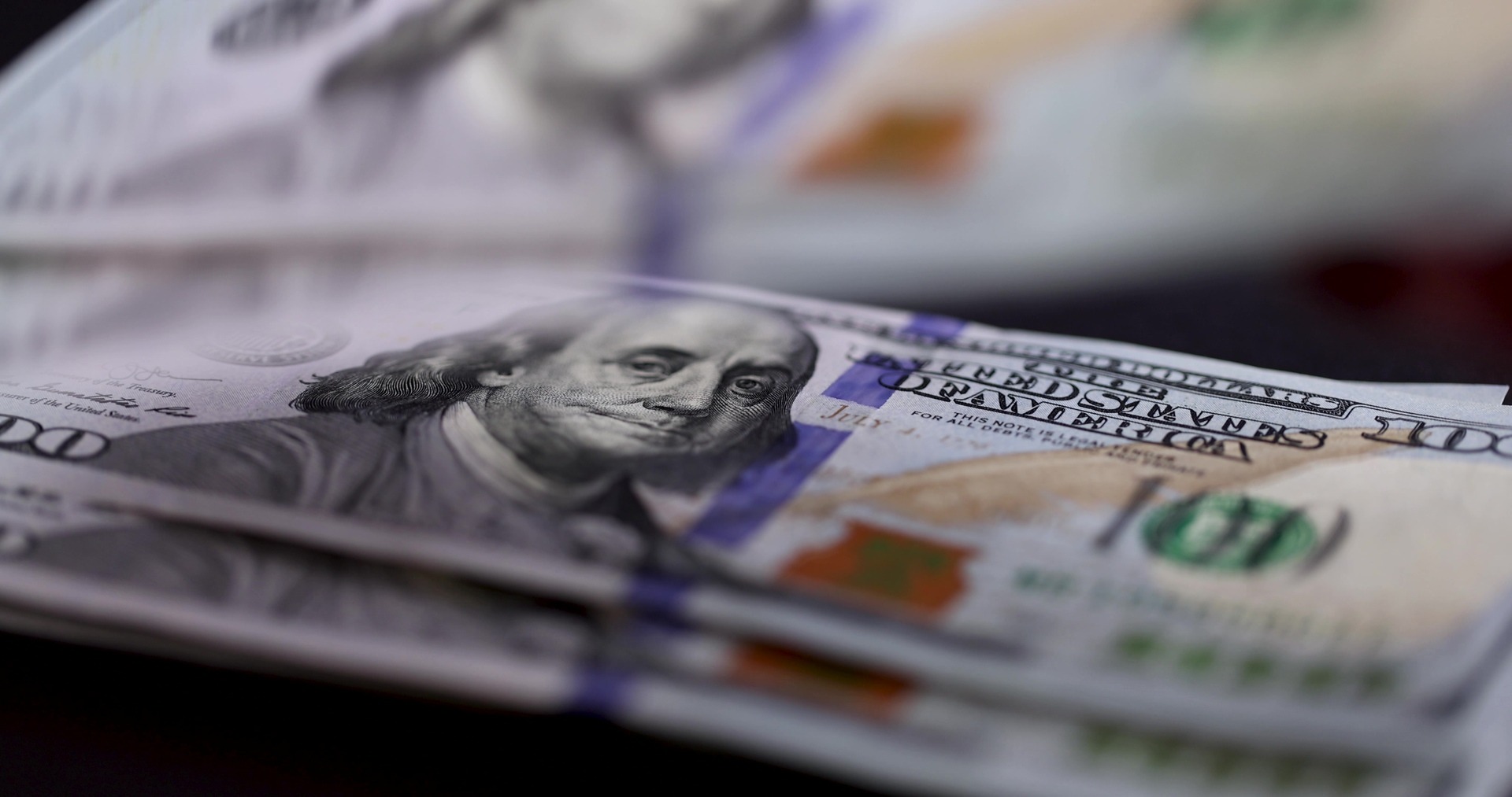 100 dollars bills on a table for a minimum investment