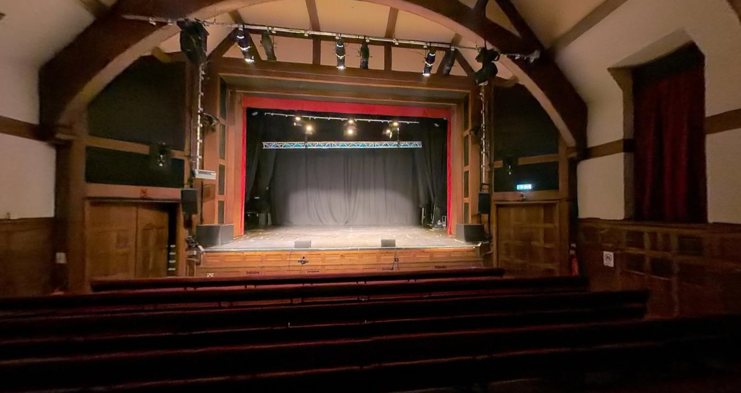The Pleasance Theatre, a theatre with a large stage and cushioned benches.