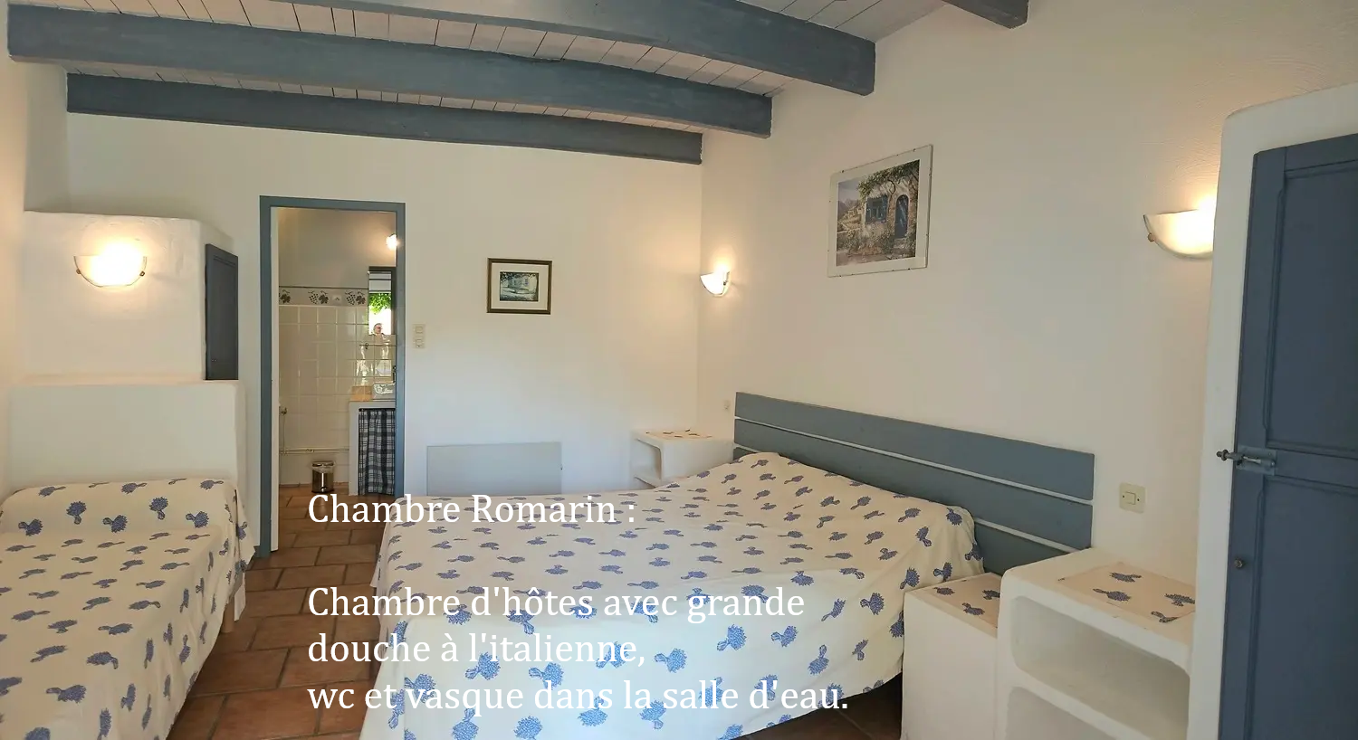 chambre romarin "la ramade" avec un grand lit et un petit lit, mur blanc, poutre et placard bleu 