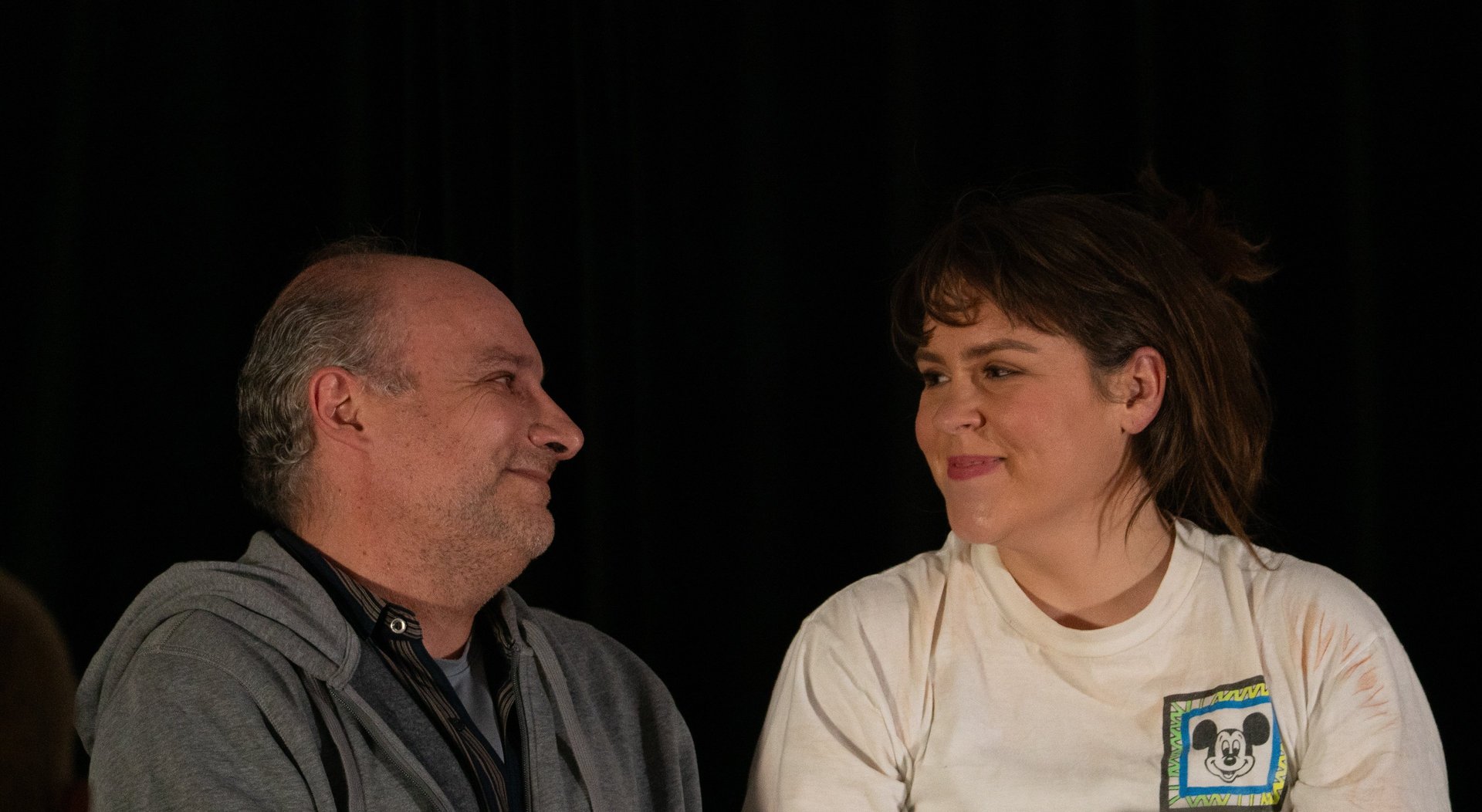 Man and woman smiling at each other.