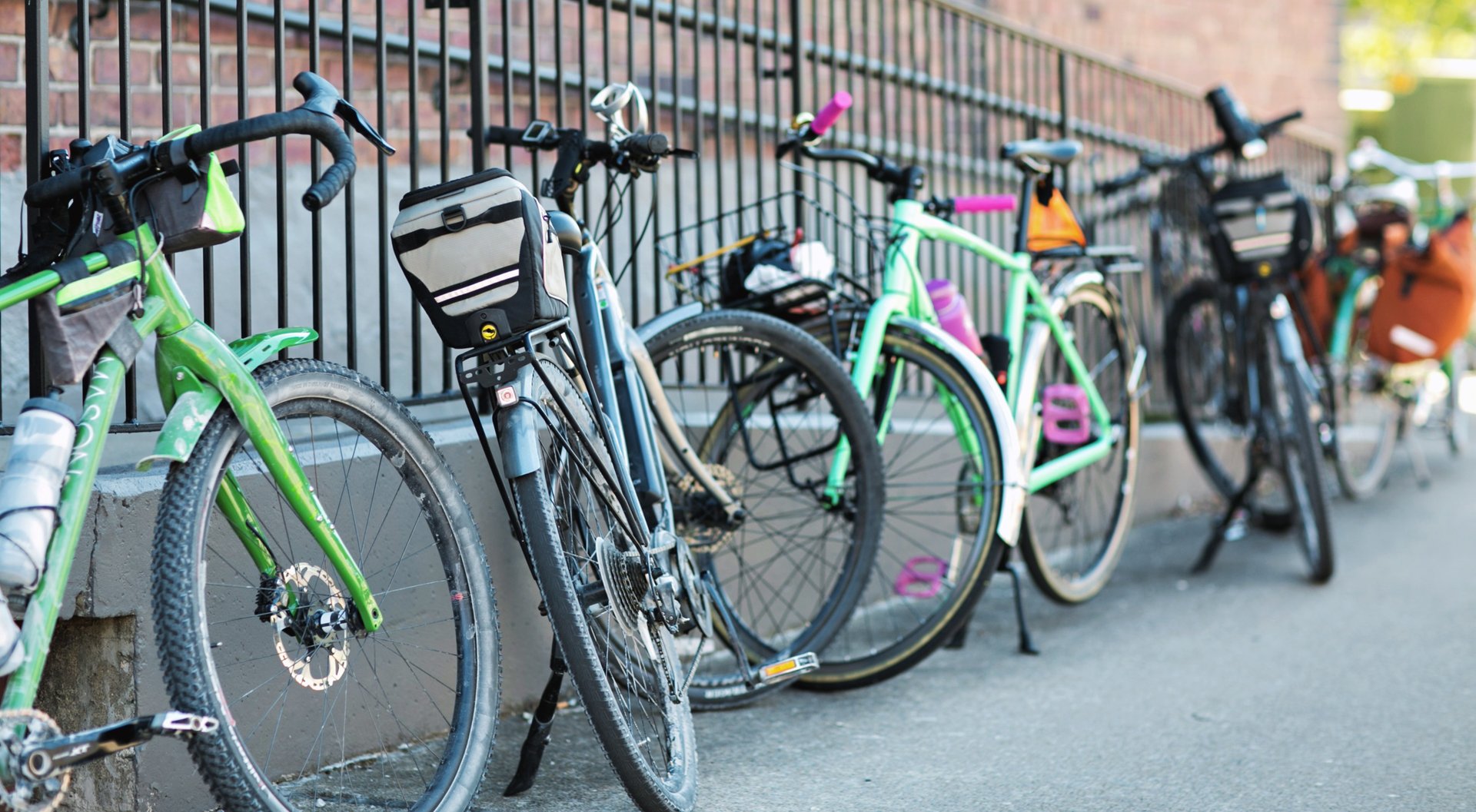 A bunch of bikes leaning up against a fence