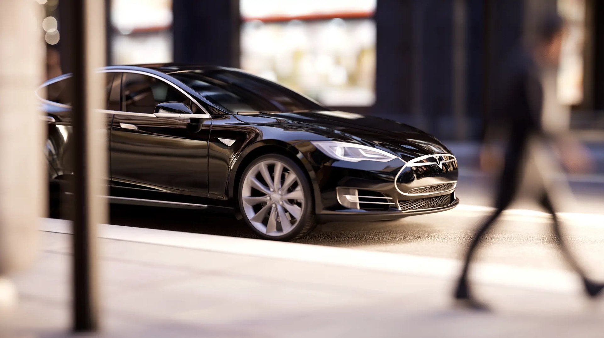 A sleek black Tesla Model S luxury electric sedan parked on a modern city street.