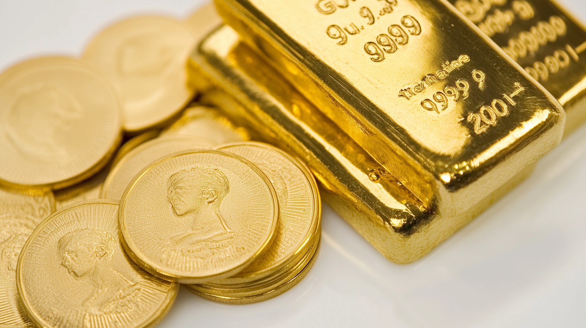high quality gold bars and coins on white surface