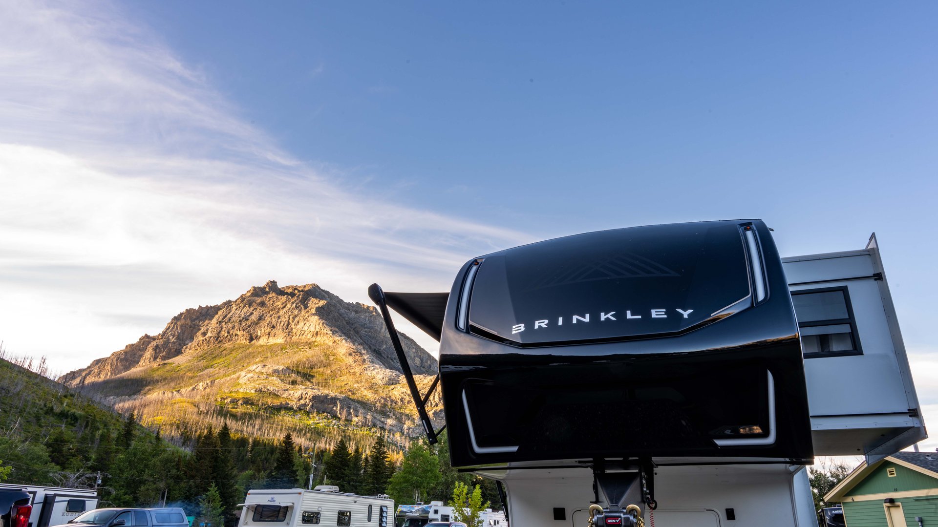 Brinkley fifth wheel camper at Waterton Lakes Campground with mountains in the background.