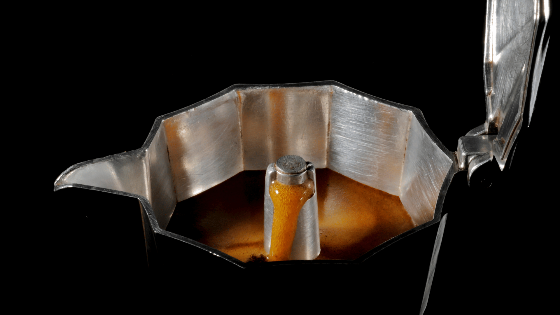 "Cafeteira italiana com a tampa aberta cheia de café fresco, ilustrando o preparo de café  Curitiba