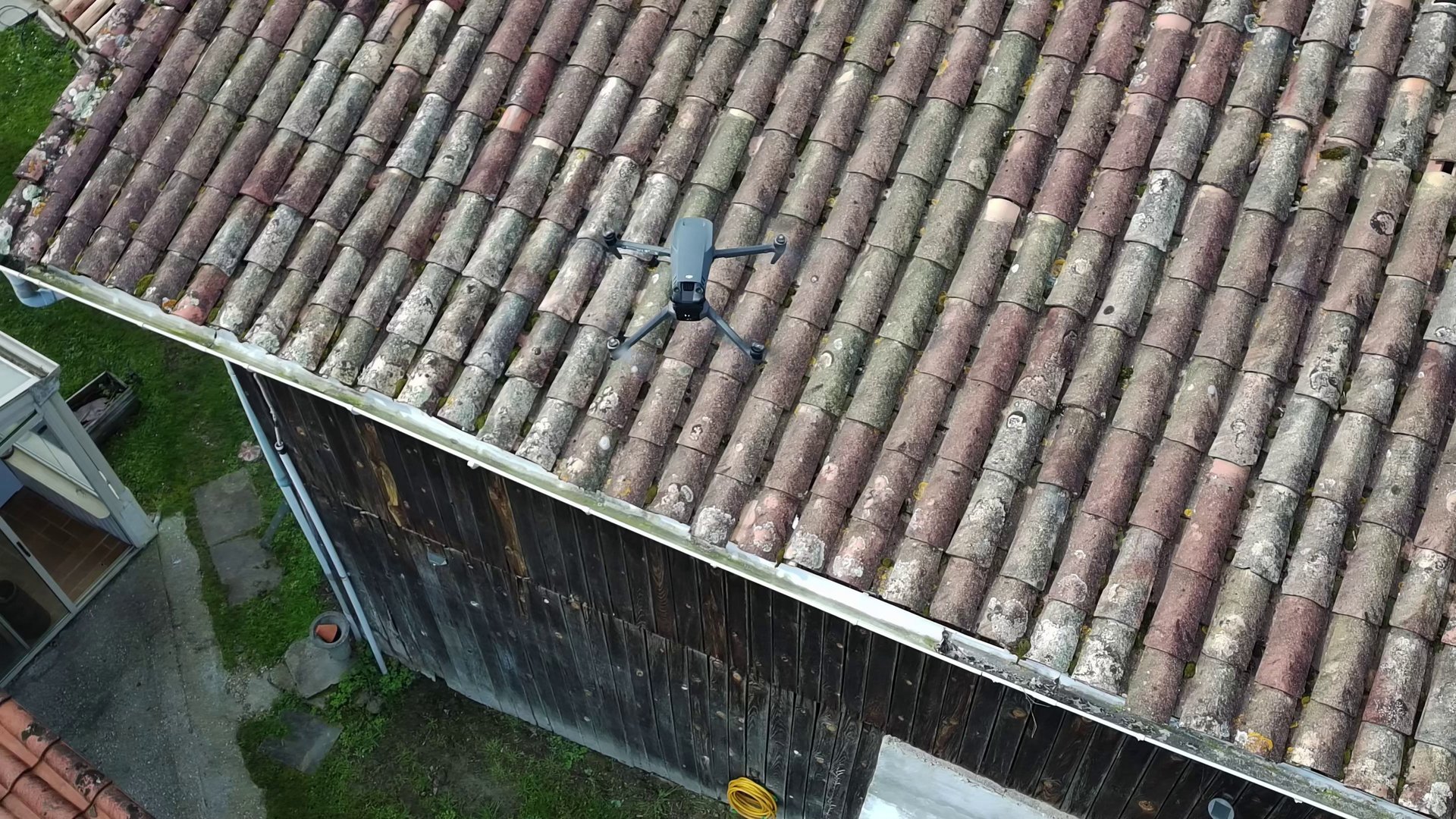 Drone d'inspection professionnelle survolant un toit de tuiles pour l'évaluation de l'entretien