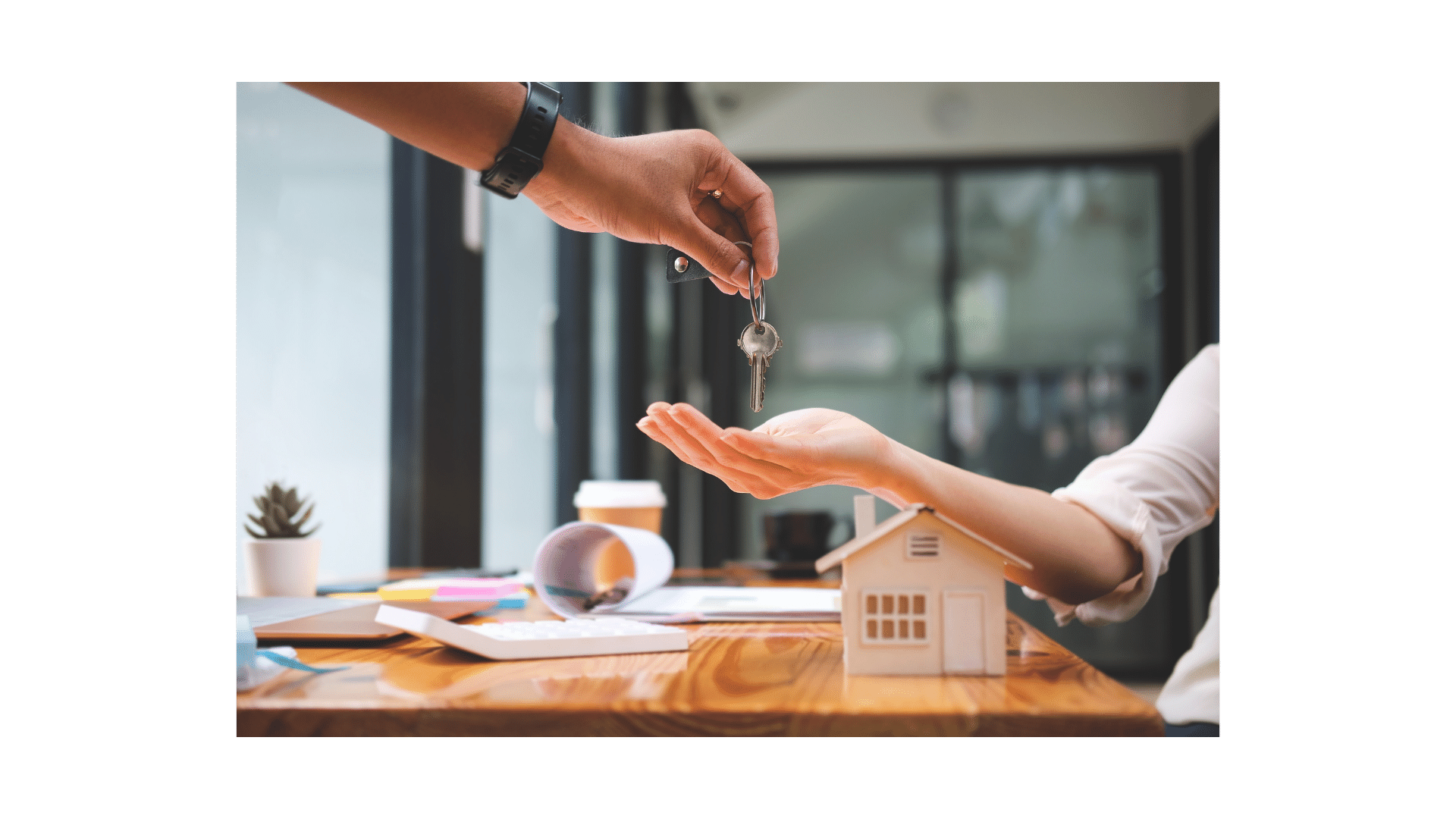a person handing a keychaik to a house