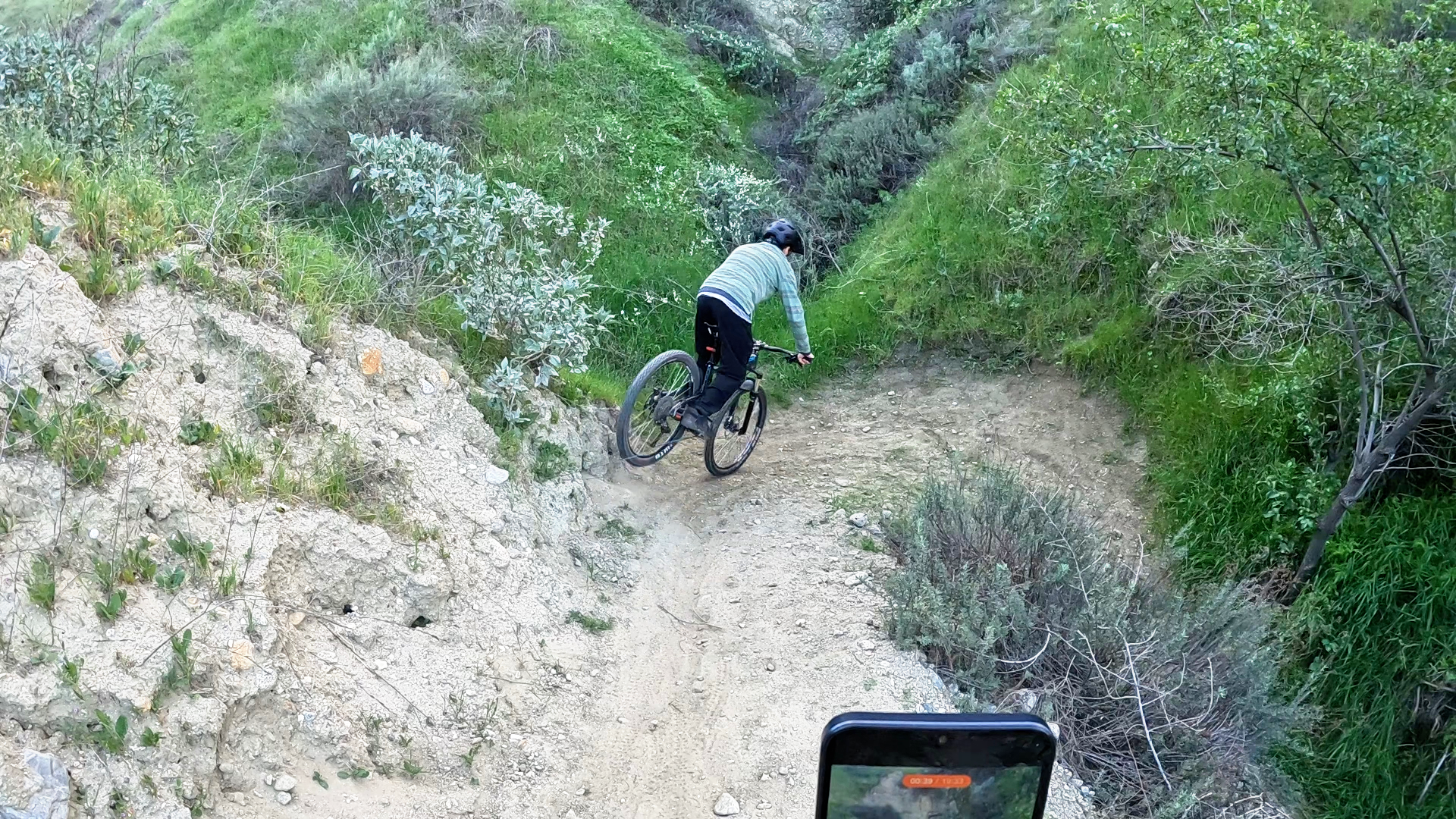 Mountain biker initiating a stoppie before a tight switchback by applying controlled front brake pre