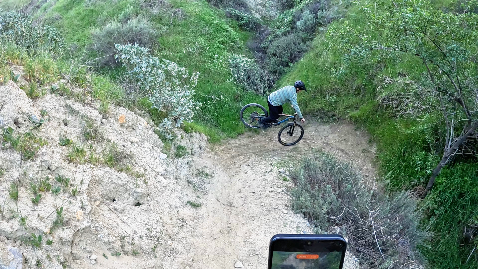 Mountain biker rotating shoulders to pivot rear wheel around a tight switchback using a stoppie tech