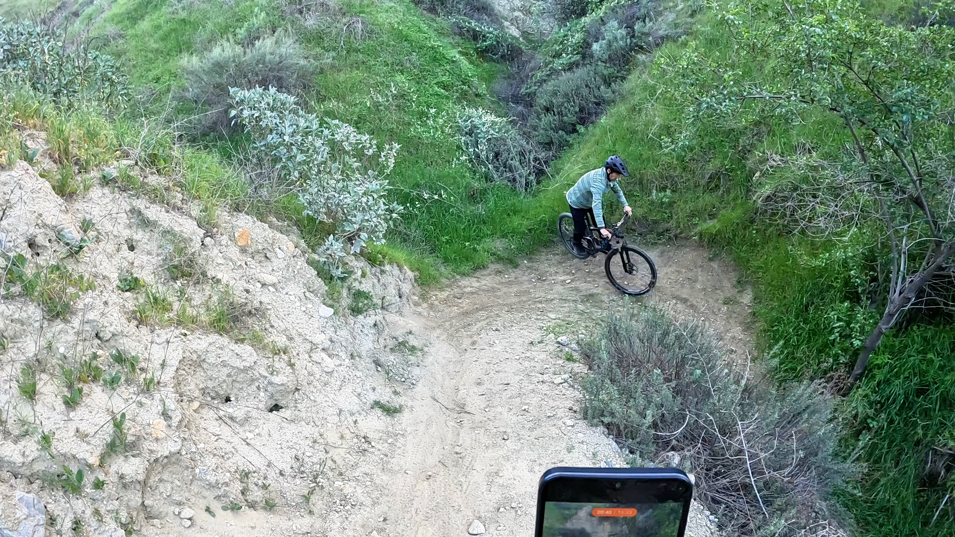 Mountain biker setting rear wheel down and straightening handlebars after completing a tight switchb