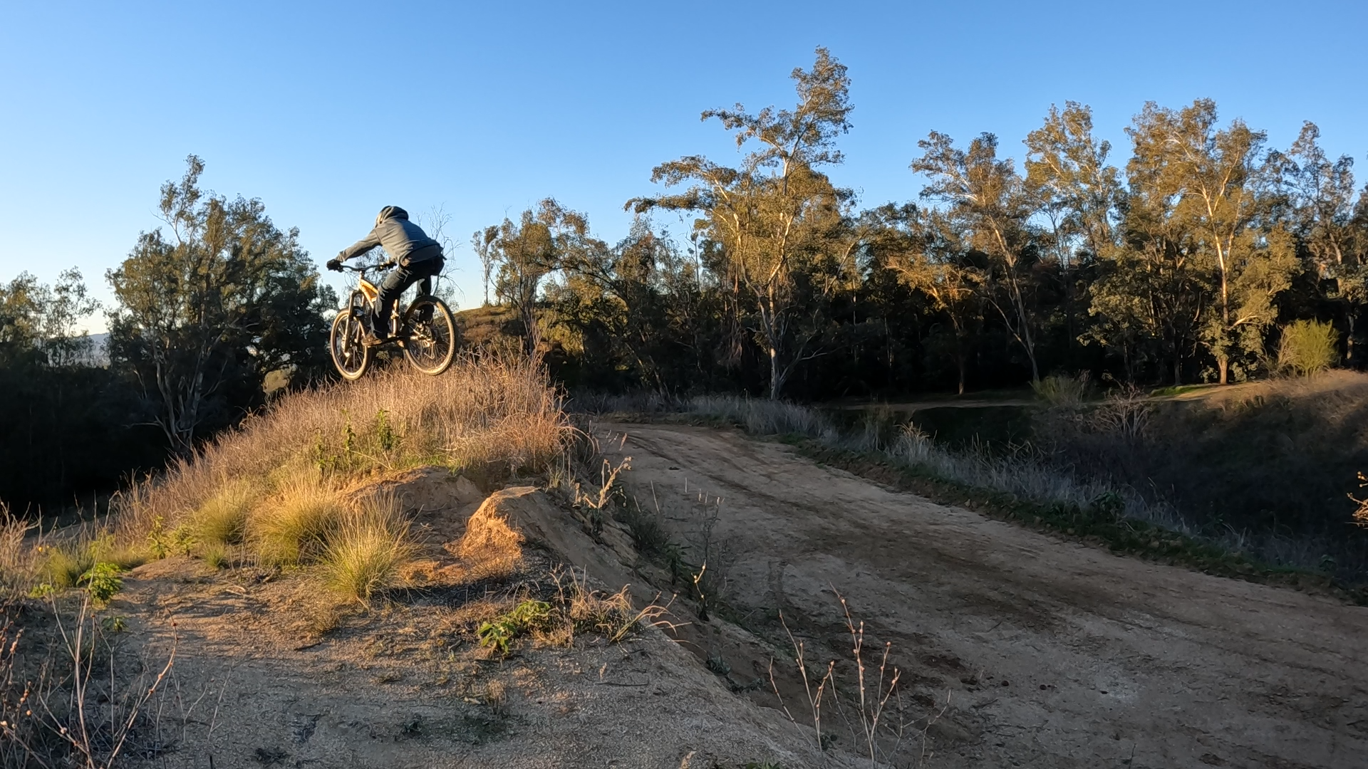 Mountain biker bringing the back wheel up with the scoop method on a jump