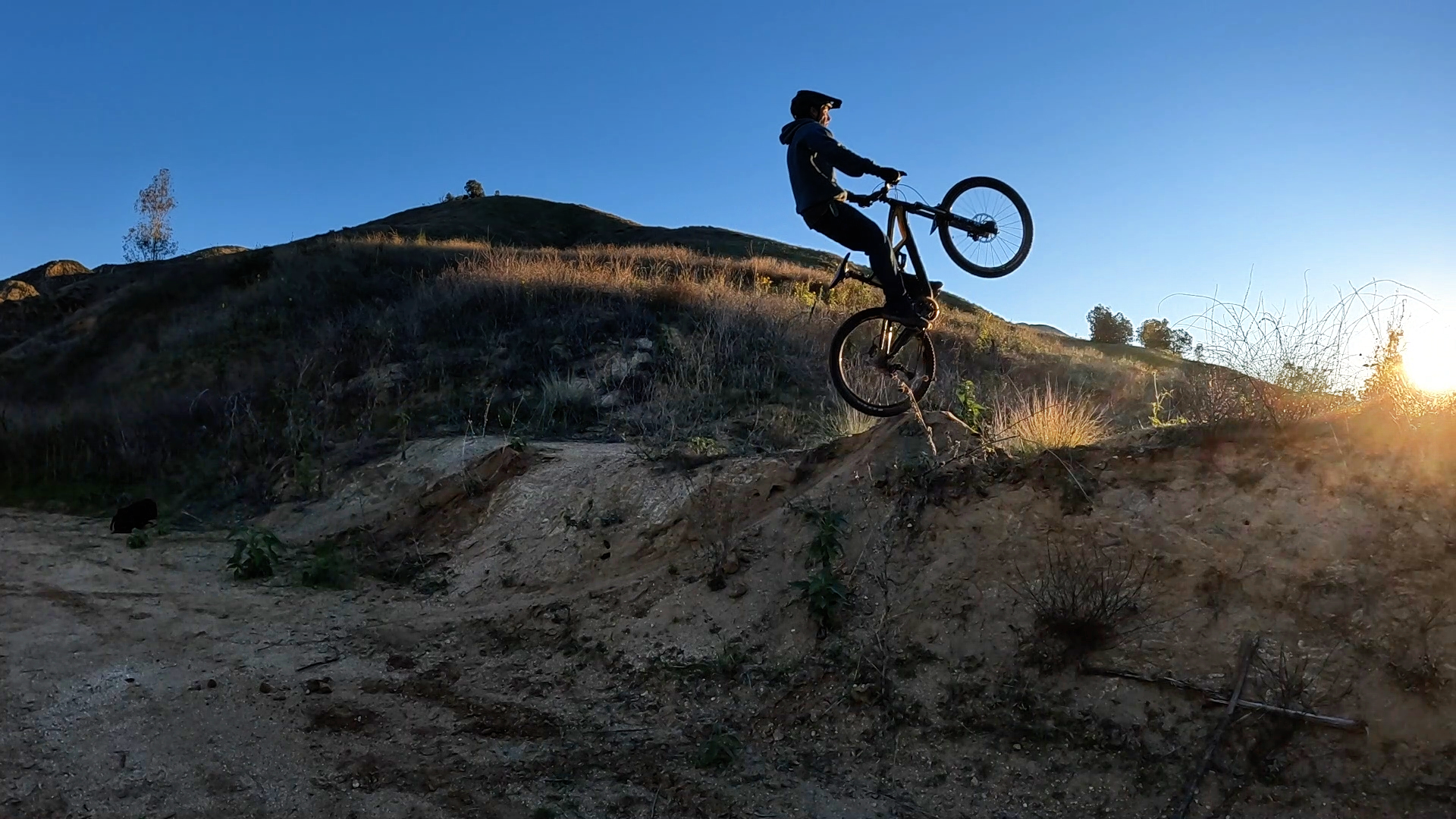mountain biker just going off a jump front wheel high in the air