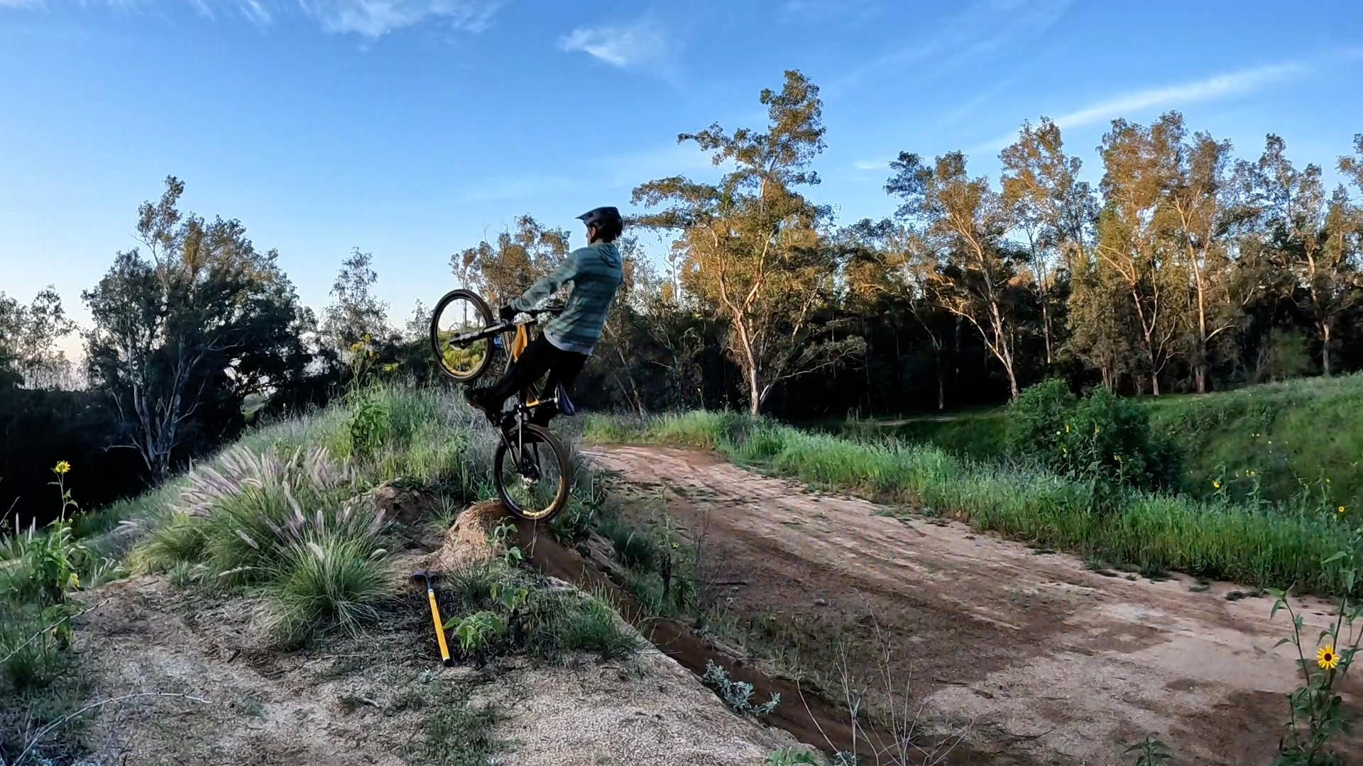 mountain biker pulling up off a jump when doing the boost technique