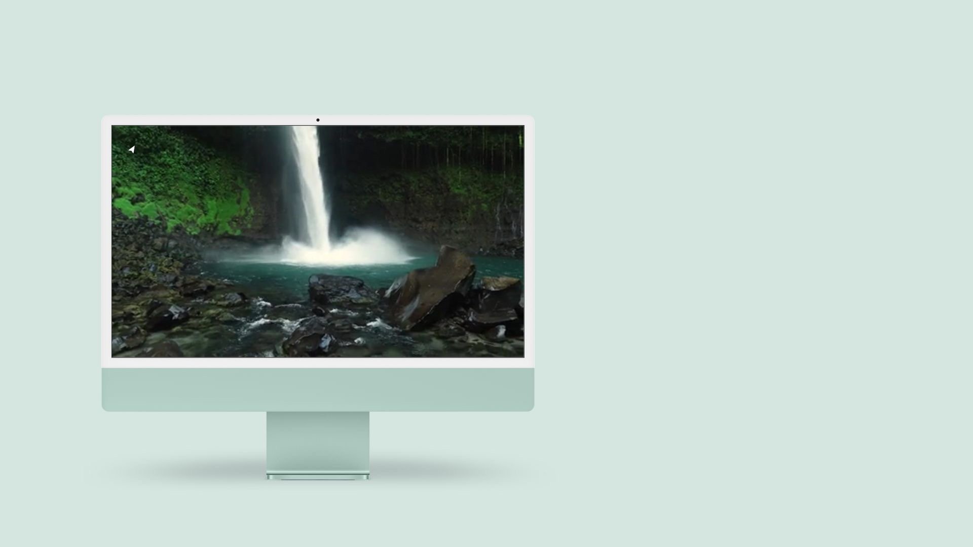 a desktop computer monitor with a waterfall in the background