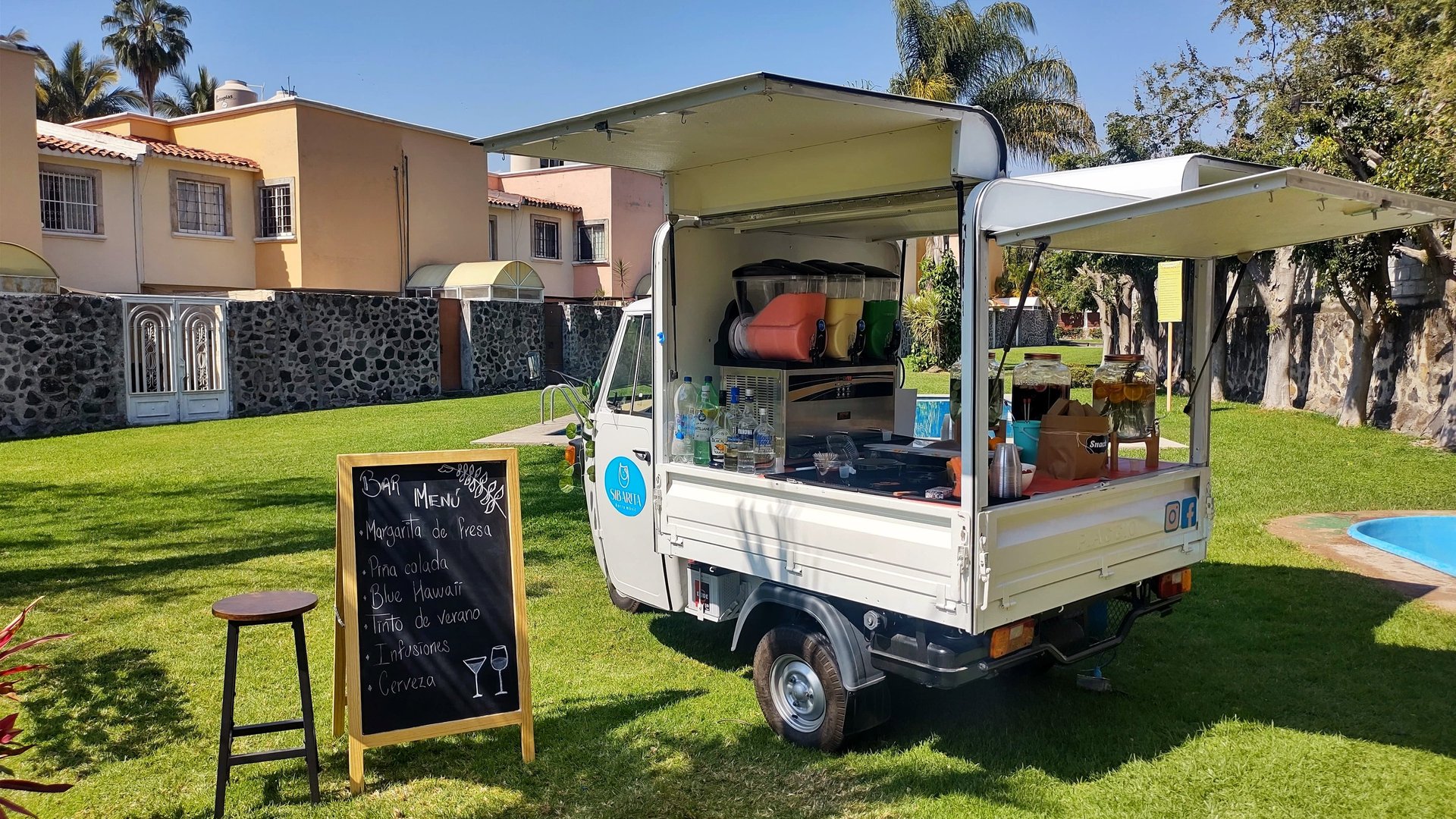 Piaggio italiano convertido en food truck con servicio de barra móvil de bebidas, en evento de día