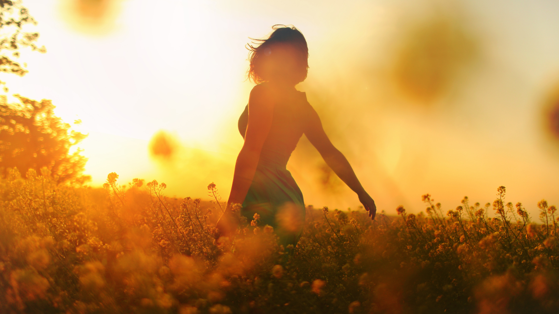 a woman walking through a field of flowers